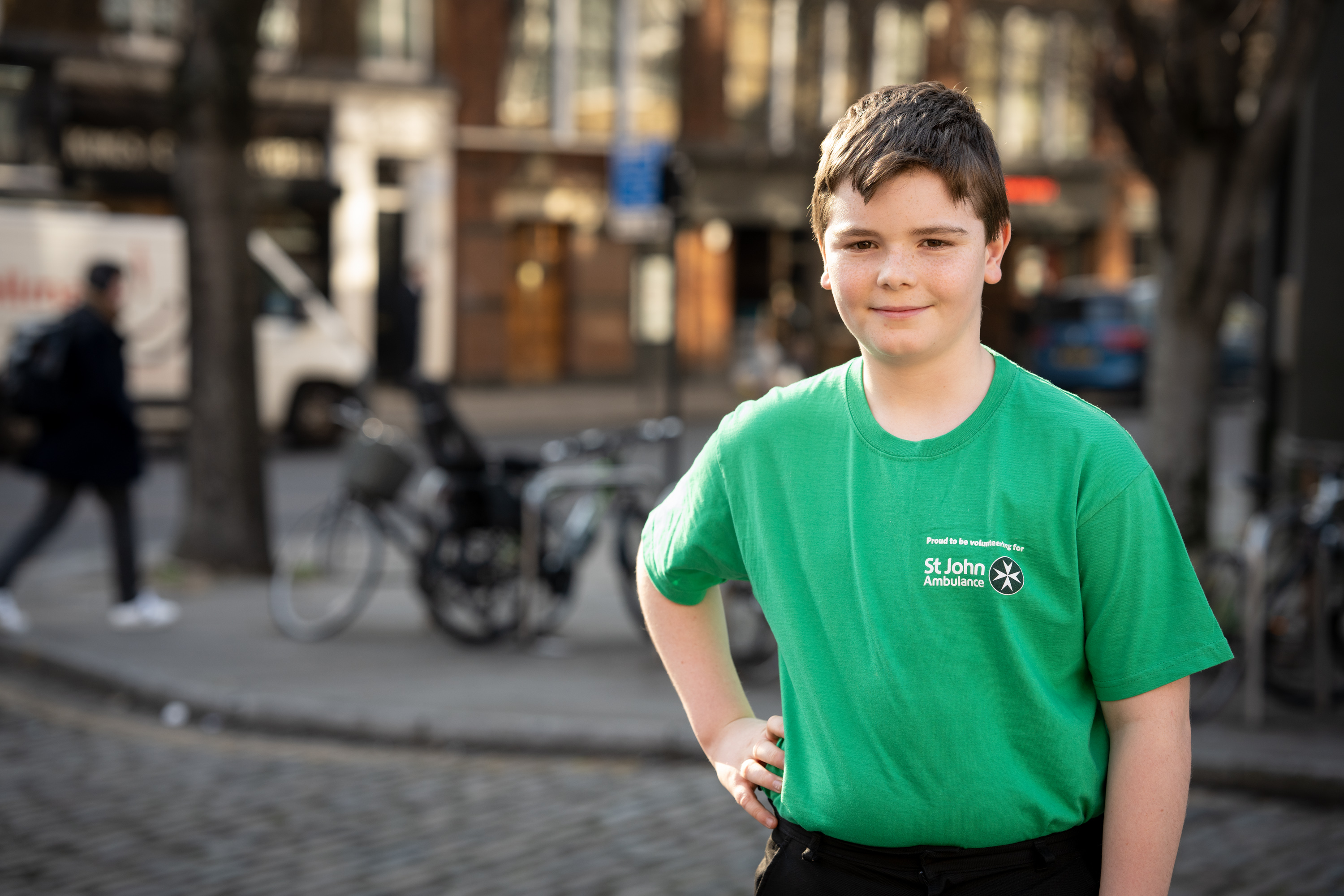 Boy wearing a green t-shirt and resting his hand on his hip