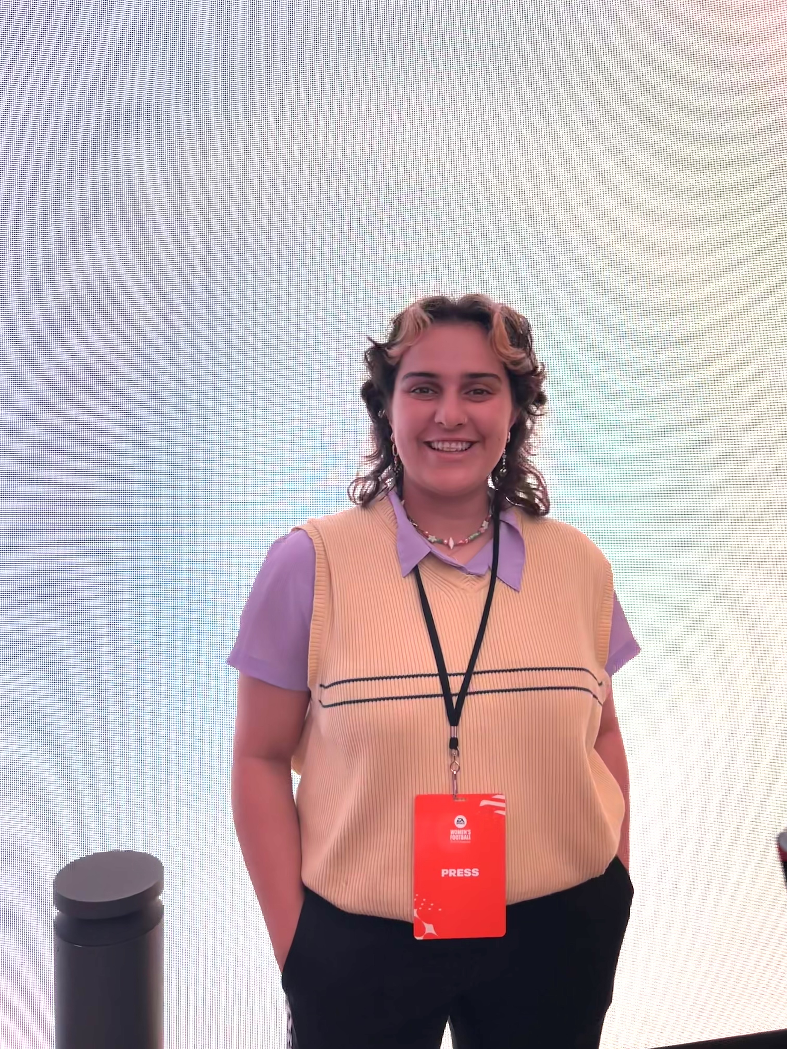 Woman wearing a lanyard and looking at the camera