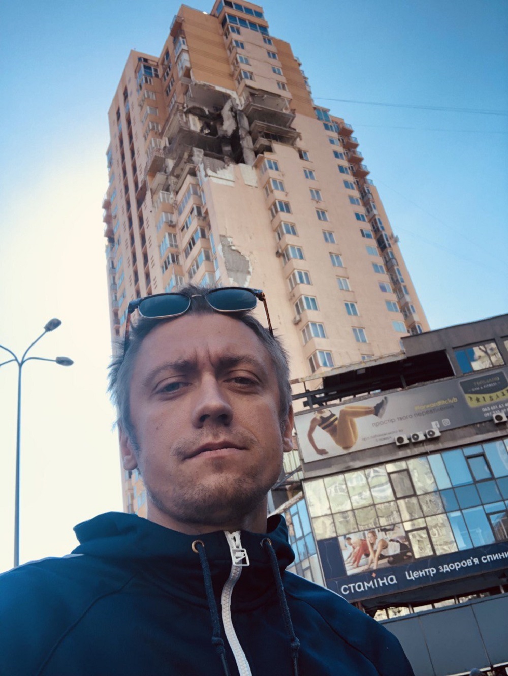 Man looking at the camera and standing in front of a building 