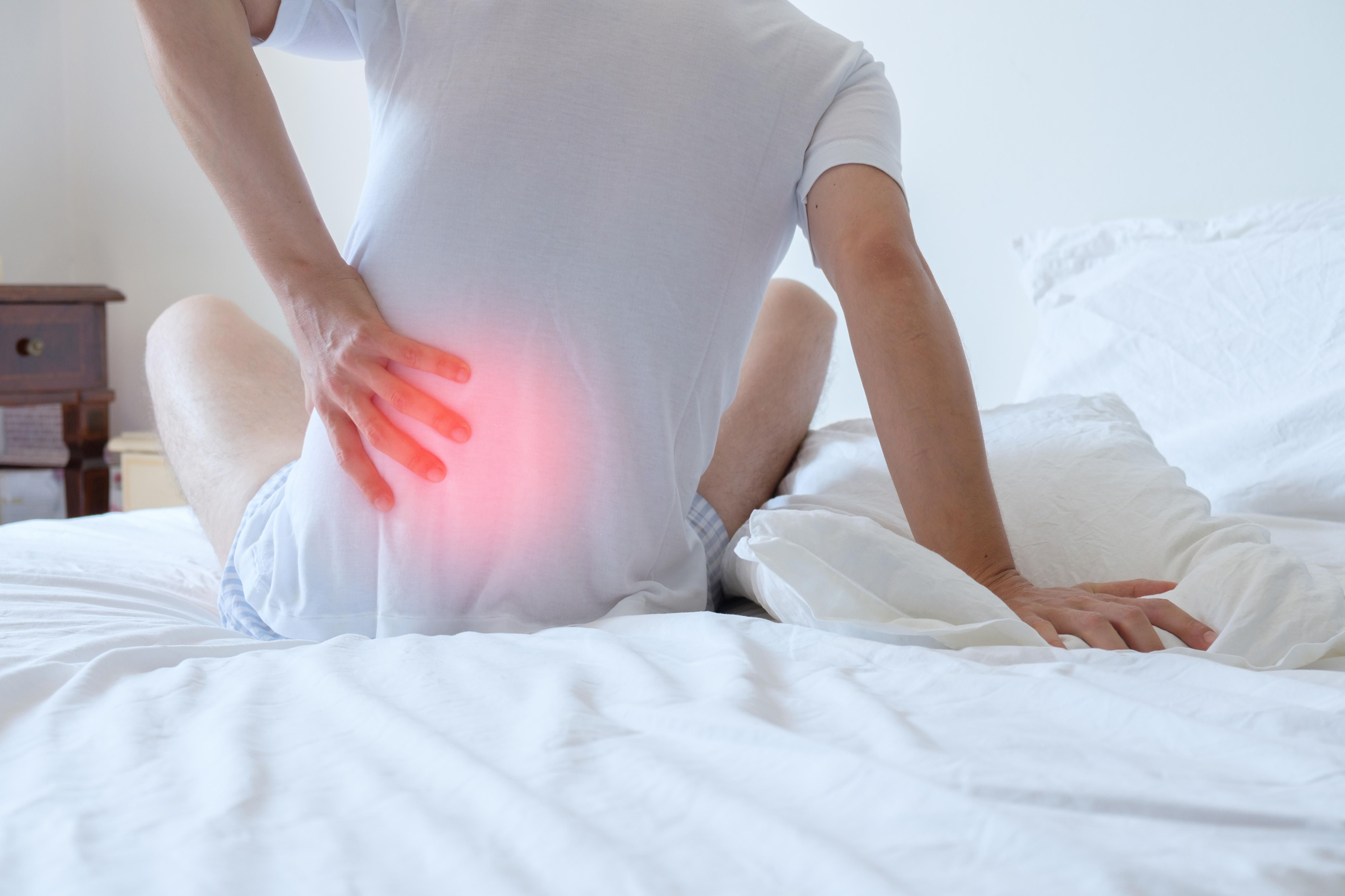 Man waking up with back pain from mattress