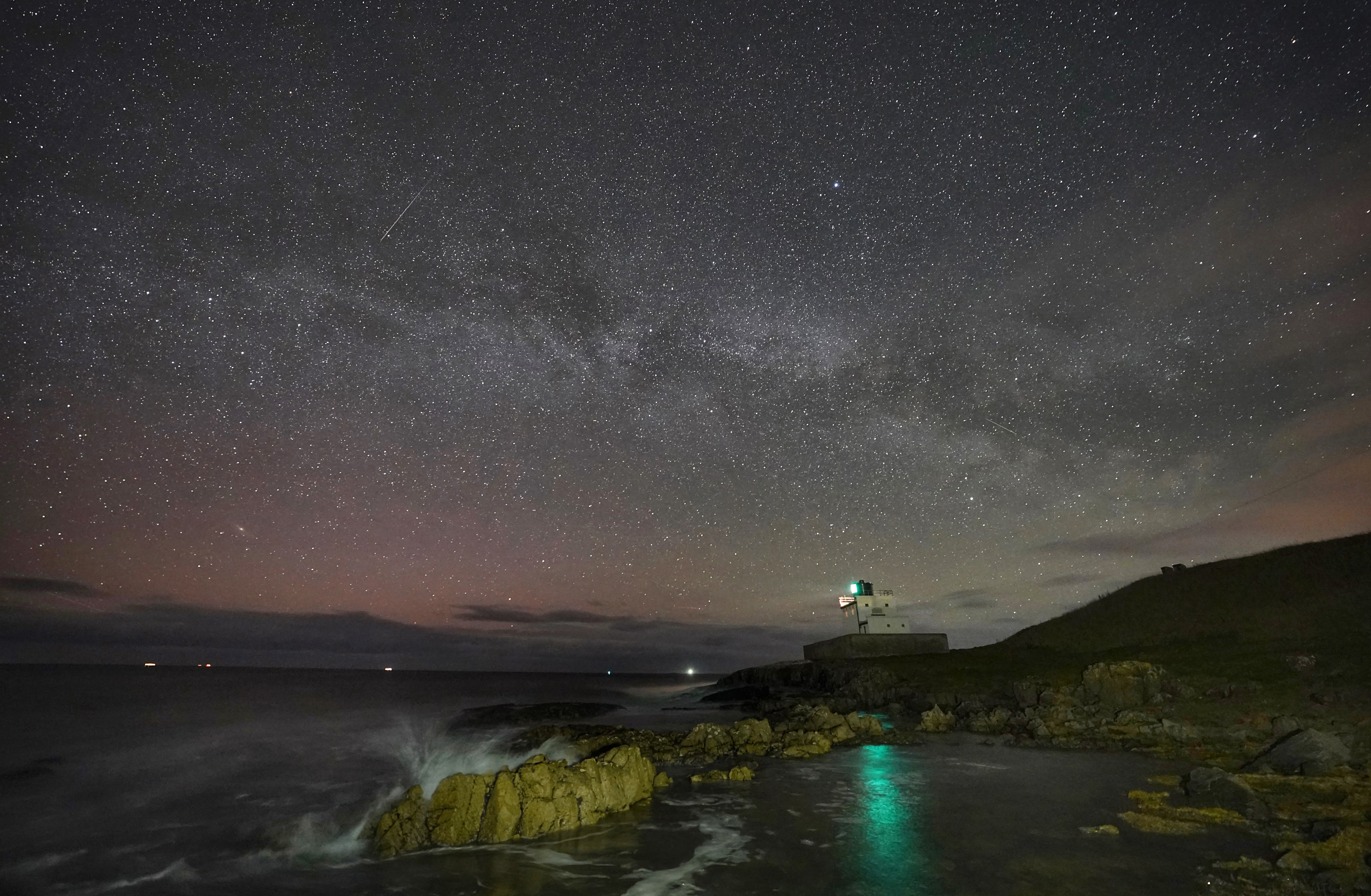 The Milky Way core rises at 3.00am over Bamburgh Lighthouse in Northumberland on the North East