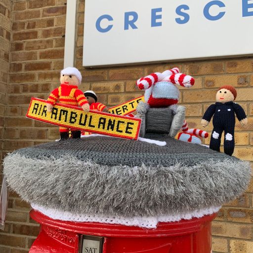 Little crocheted figures on a postbox