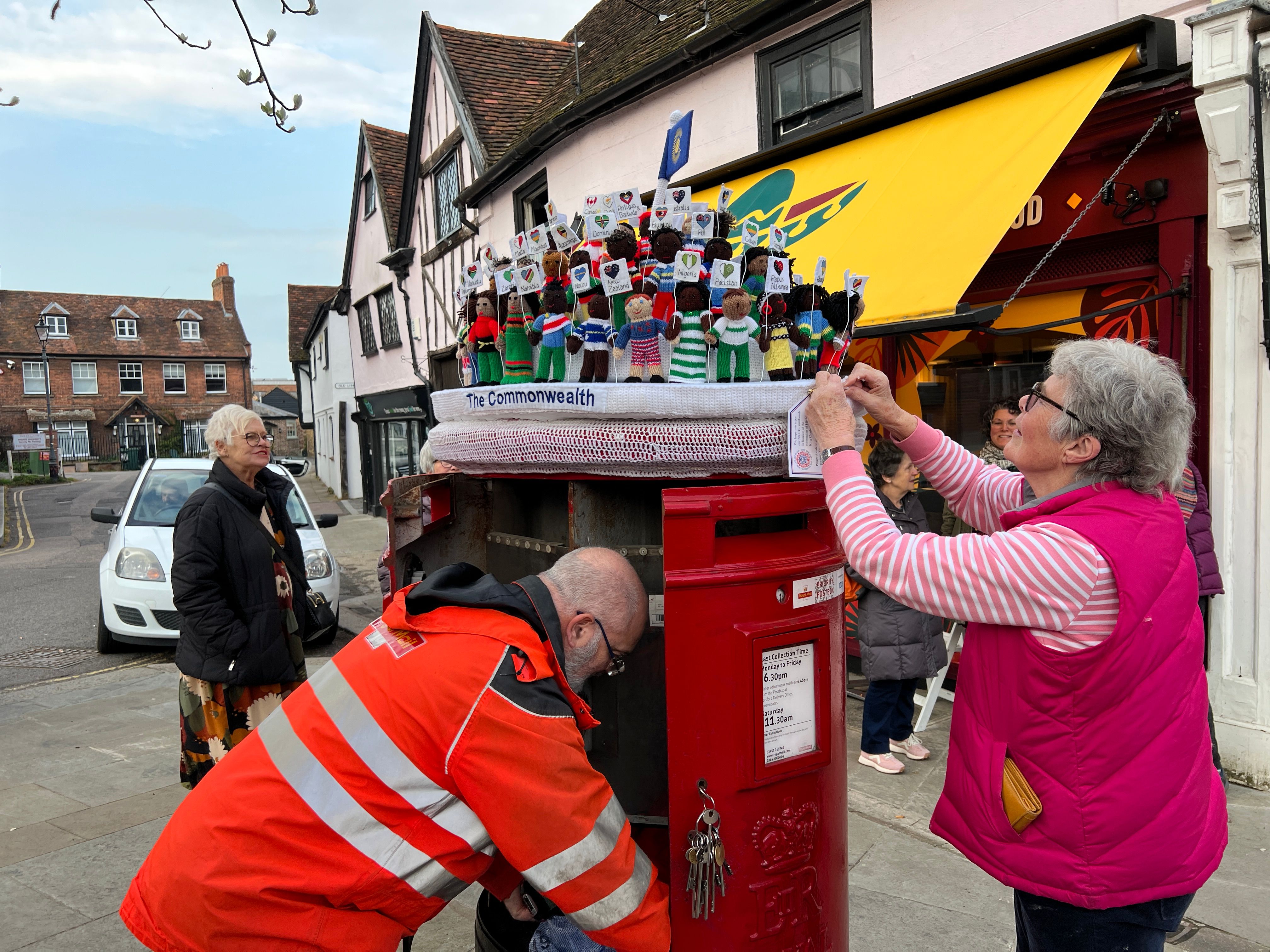 Woman putting postbox topper on top of postbox