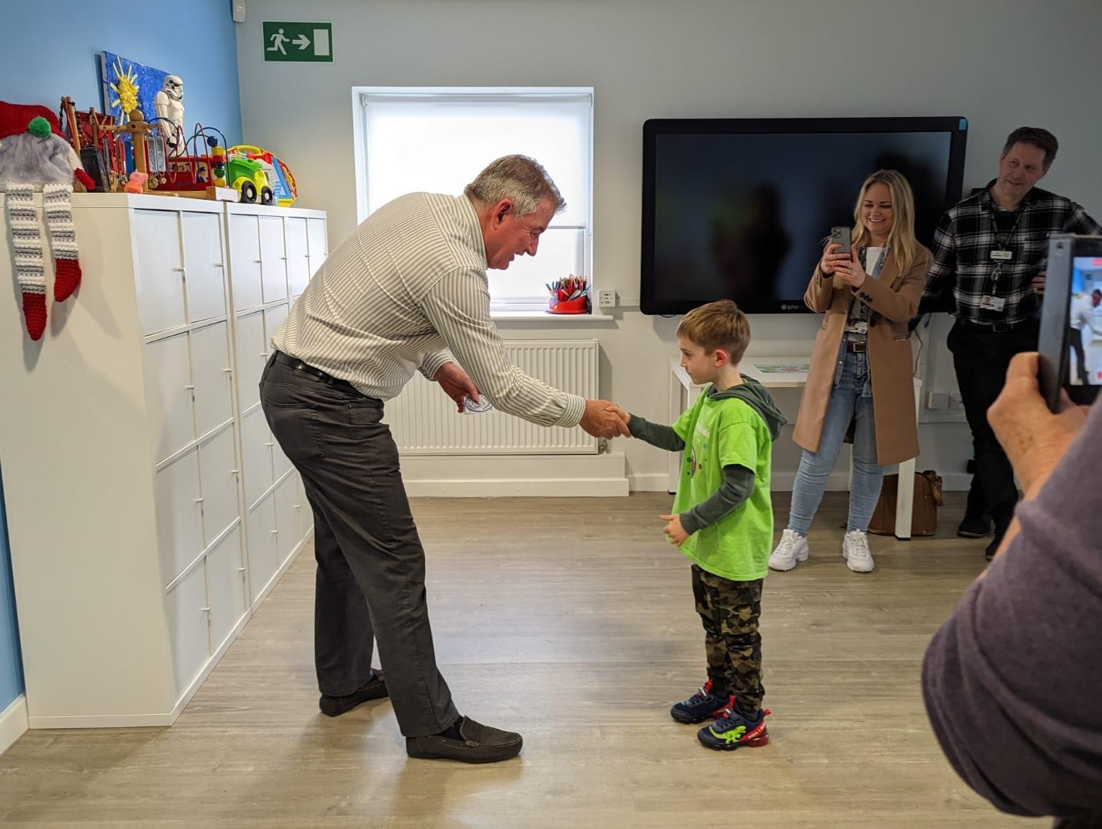 Man shaking boy's hand 