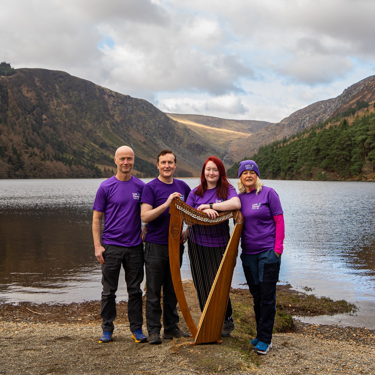 Group posing behind a harp