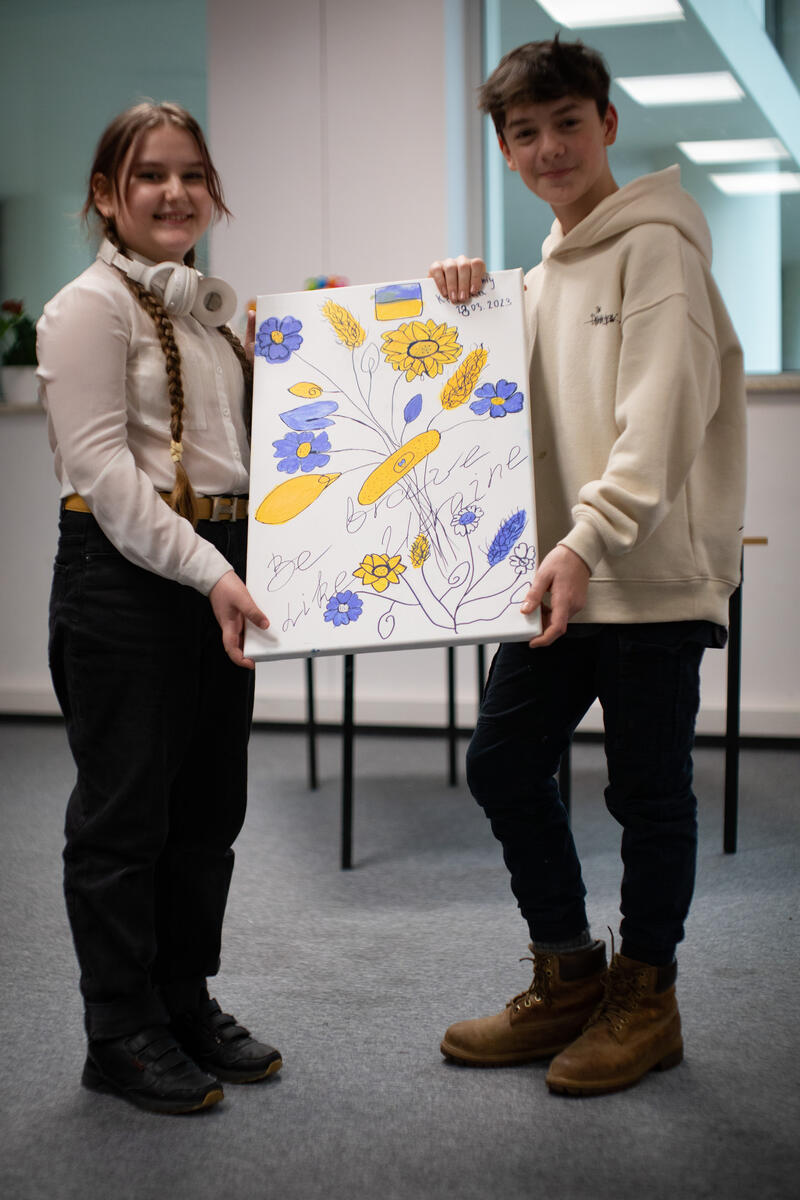 Boy and girl holding a painting 