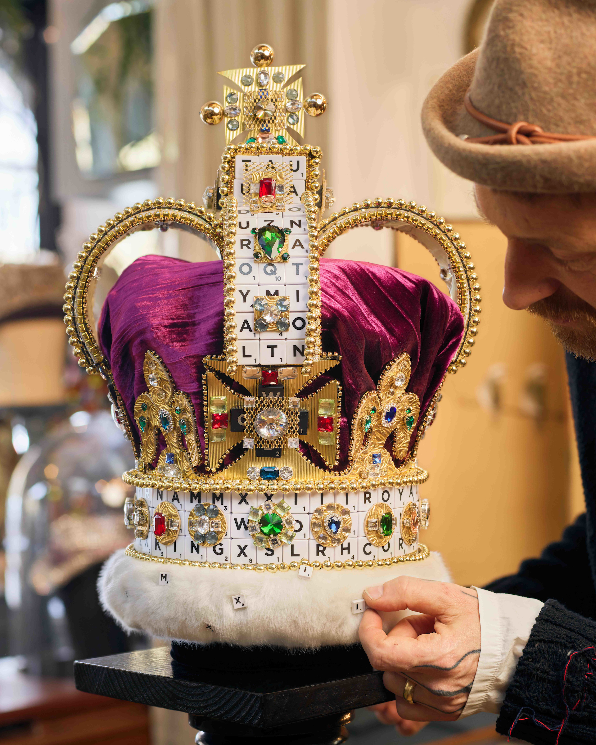 Man looking at a crown which he is holding in his hand 