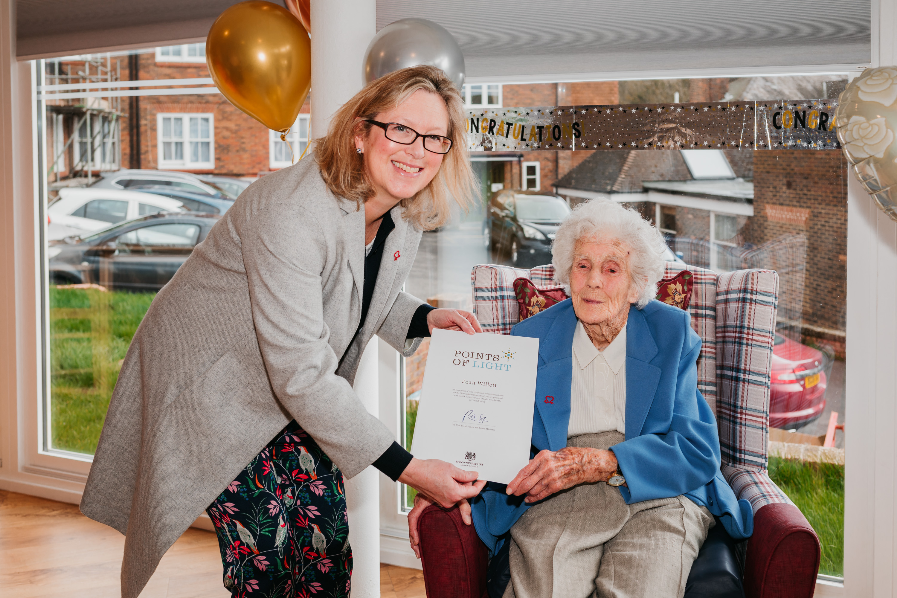 Joan Willett sat with her Points of Light Award, alongside MP for Hastings and Rye Sally-Ann Hart