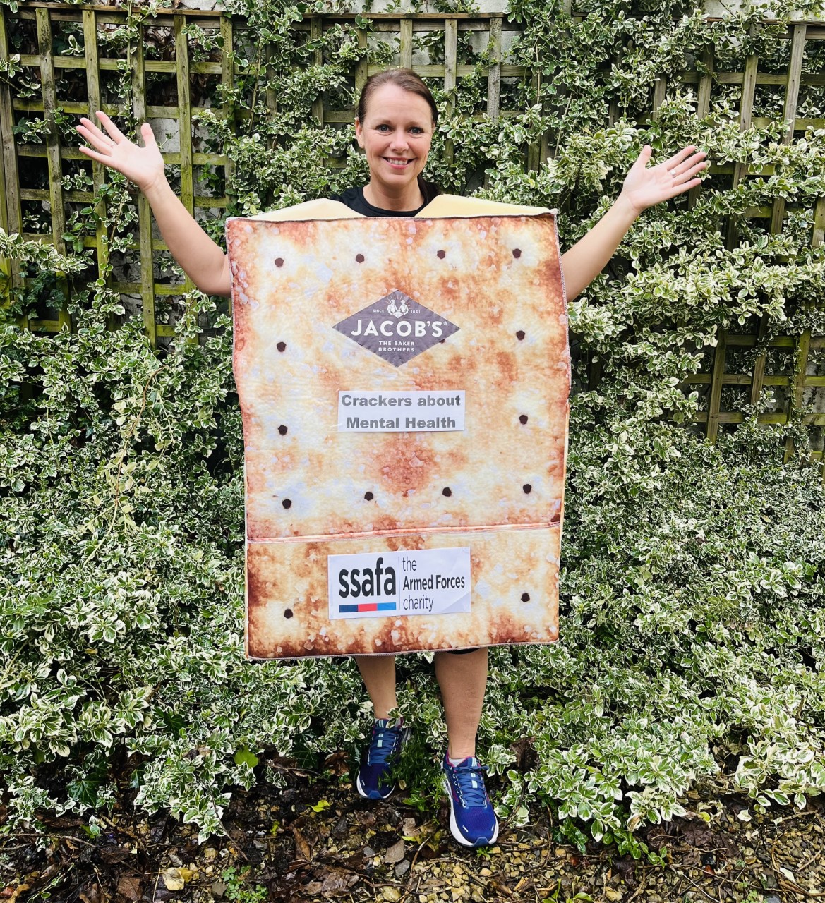 Woman wearing a cream cracker outfit, with her hands out and outstretched 