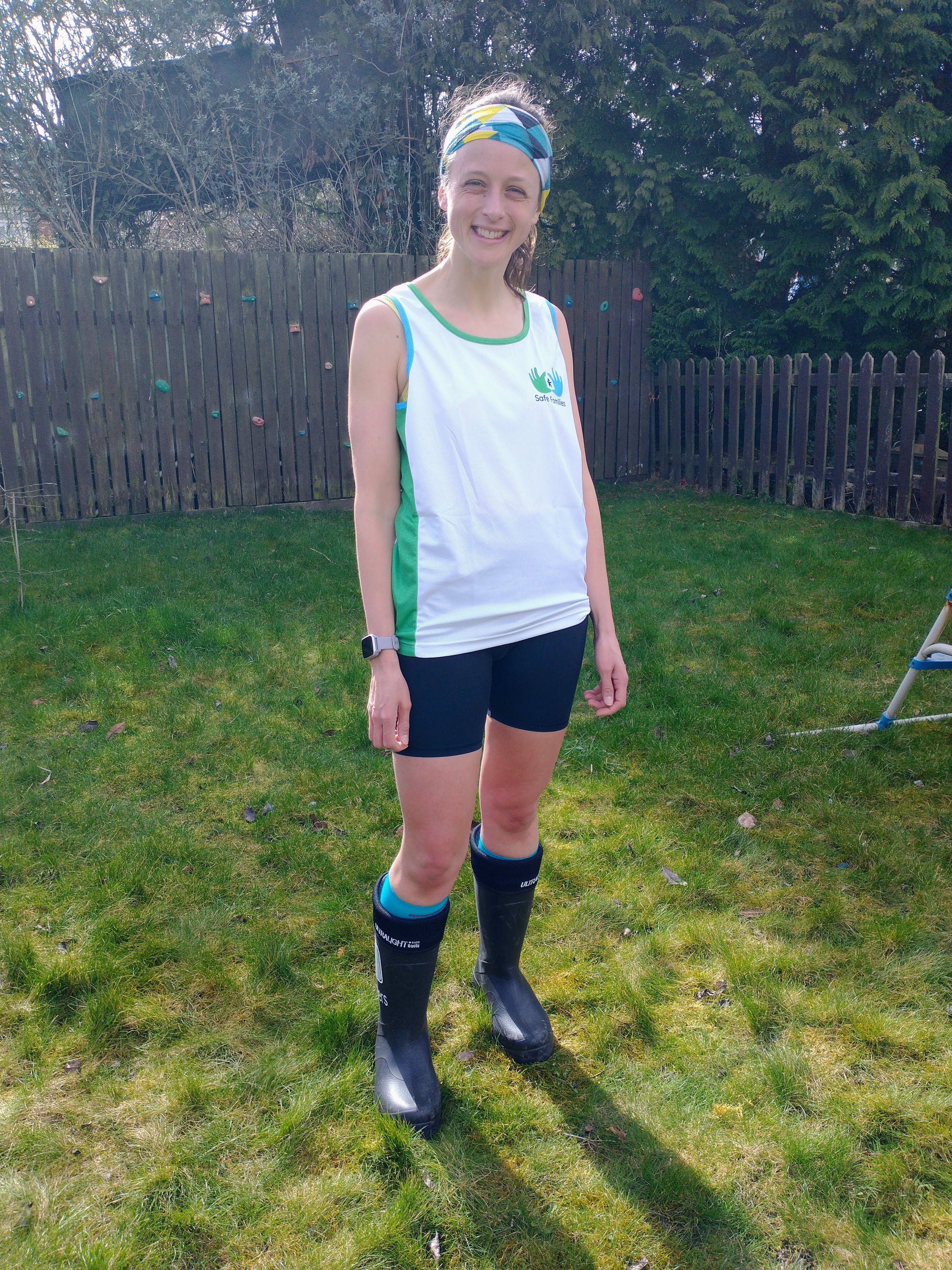 Woman standing with shorts, a tank top and trainers