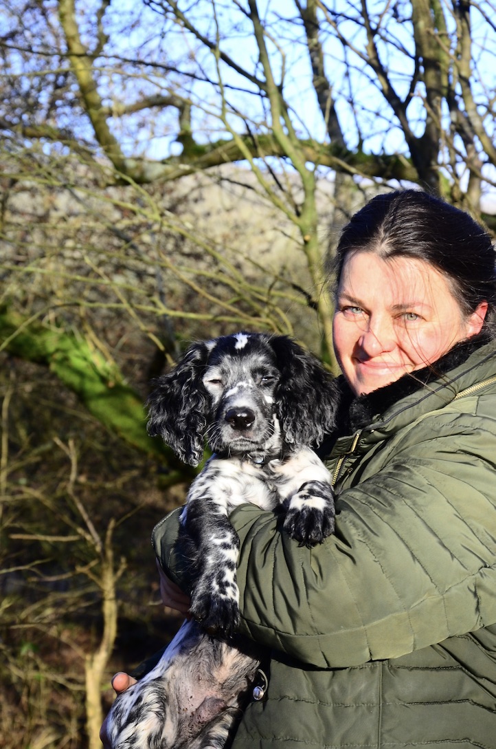 Woman holding dog and looking at the camera