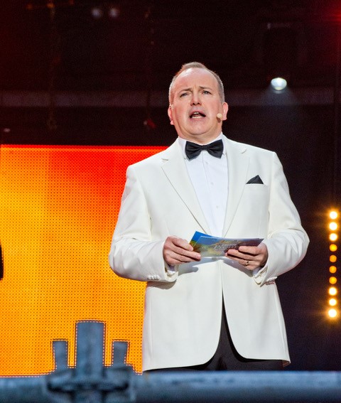 Man singing and wearing a white blazer 