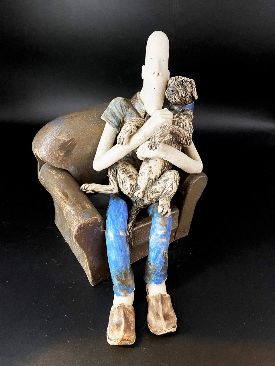Sculpture of man hugging a dog 