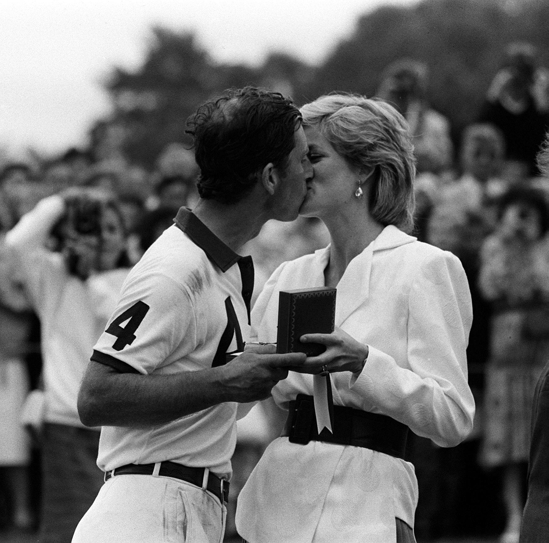The Princess of Wales presenting her husband, the Prince of Wales, with a prize and a kiss after a polo match in 1986