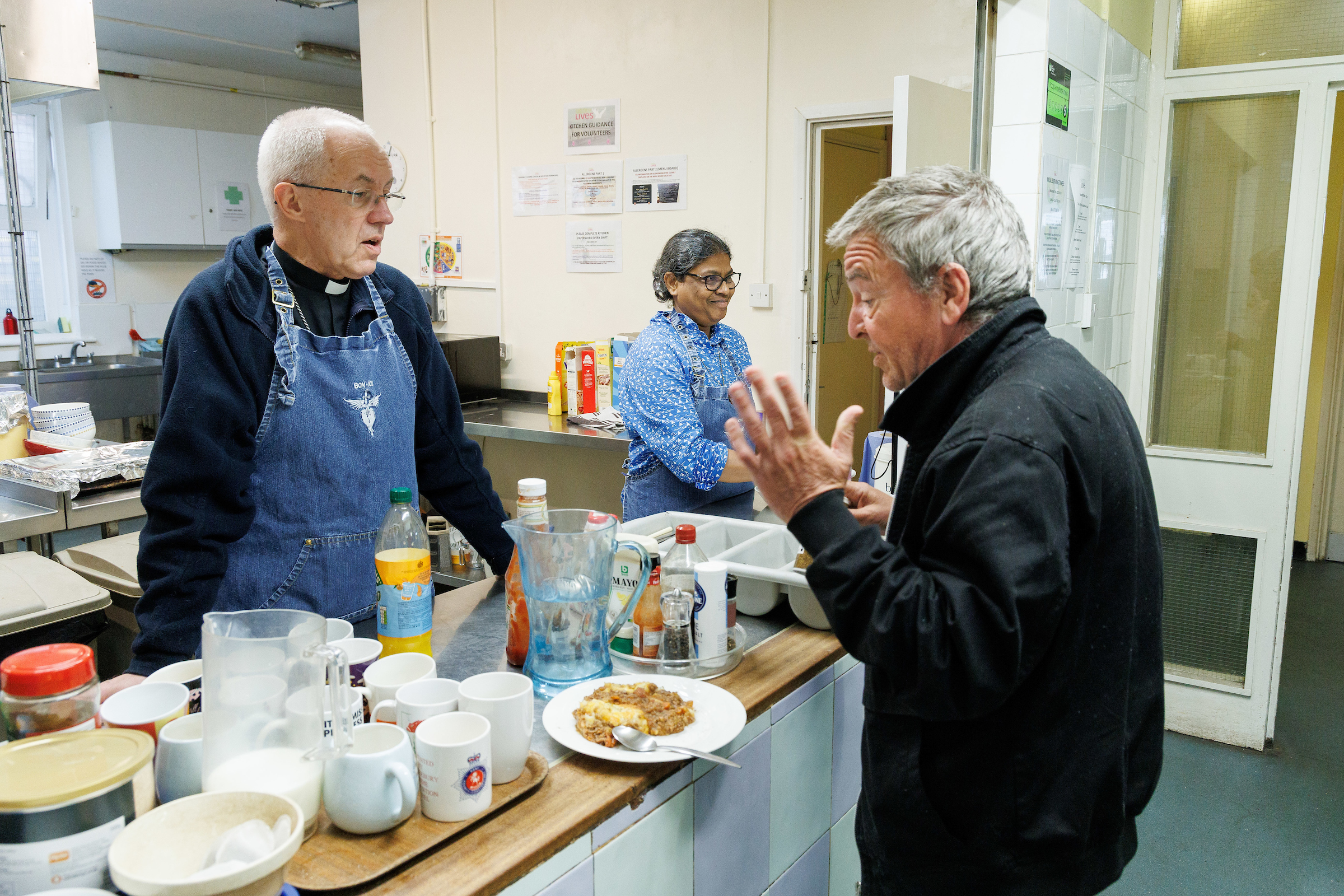 The Most Revd Justin Welby, Archbishop of Canterbury, serves lunch during his visit to the Catching Lives Open Centre