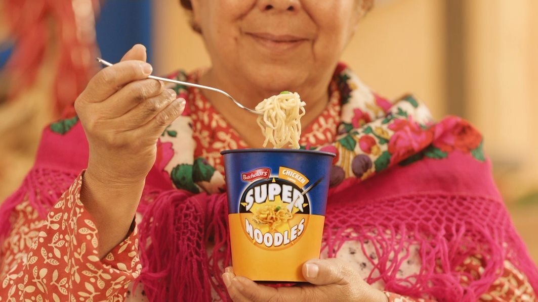 A woman eating Super Noodles