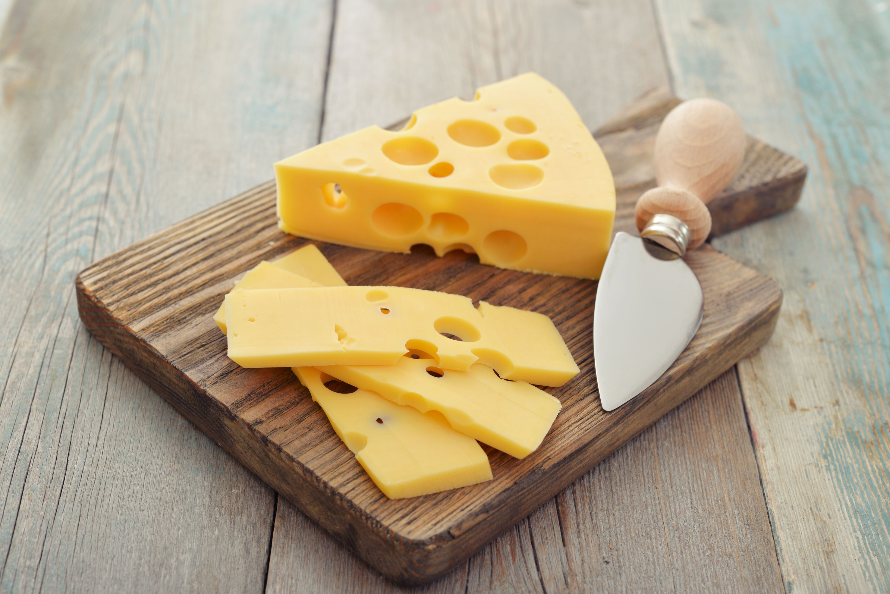 Swiss cheese on board with chopping knife