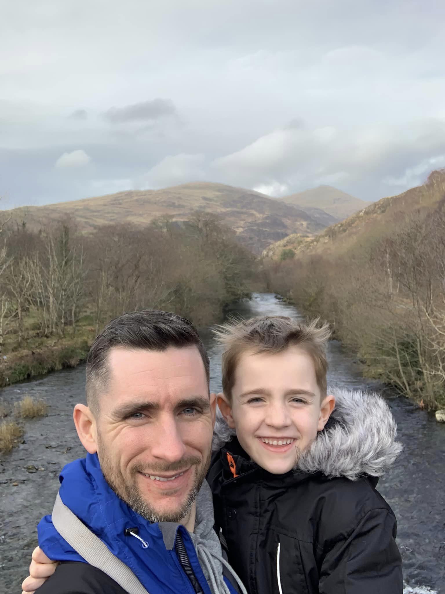 Man standing next to boy and smiling at the camera