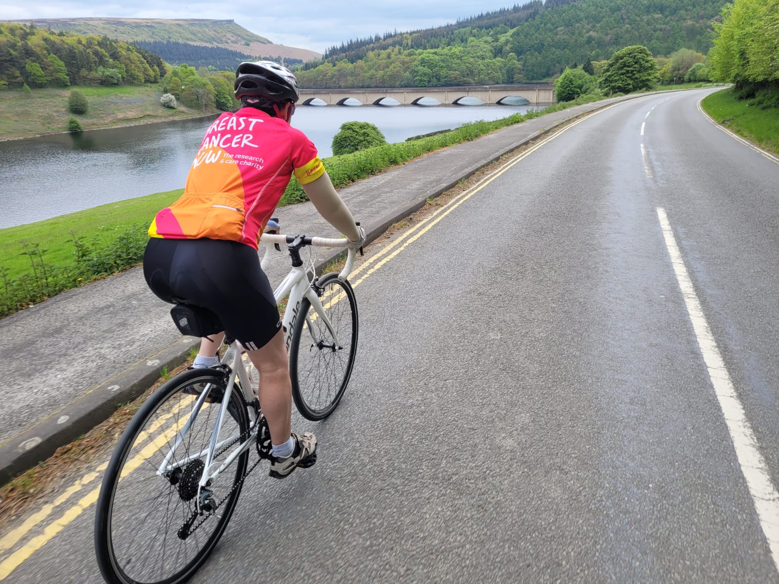 Judith Kippax cycling wearing a Breast Cancer Now t-shirt
