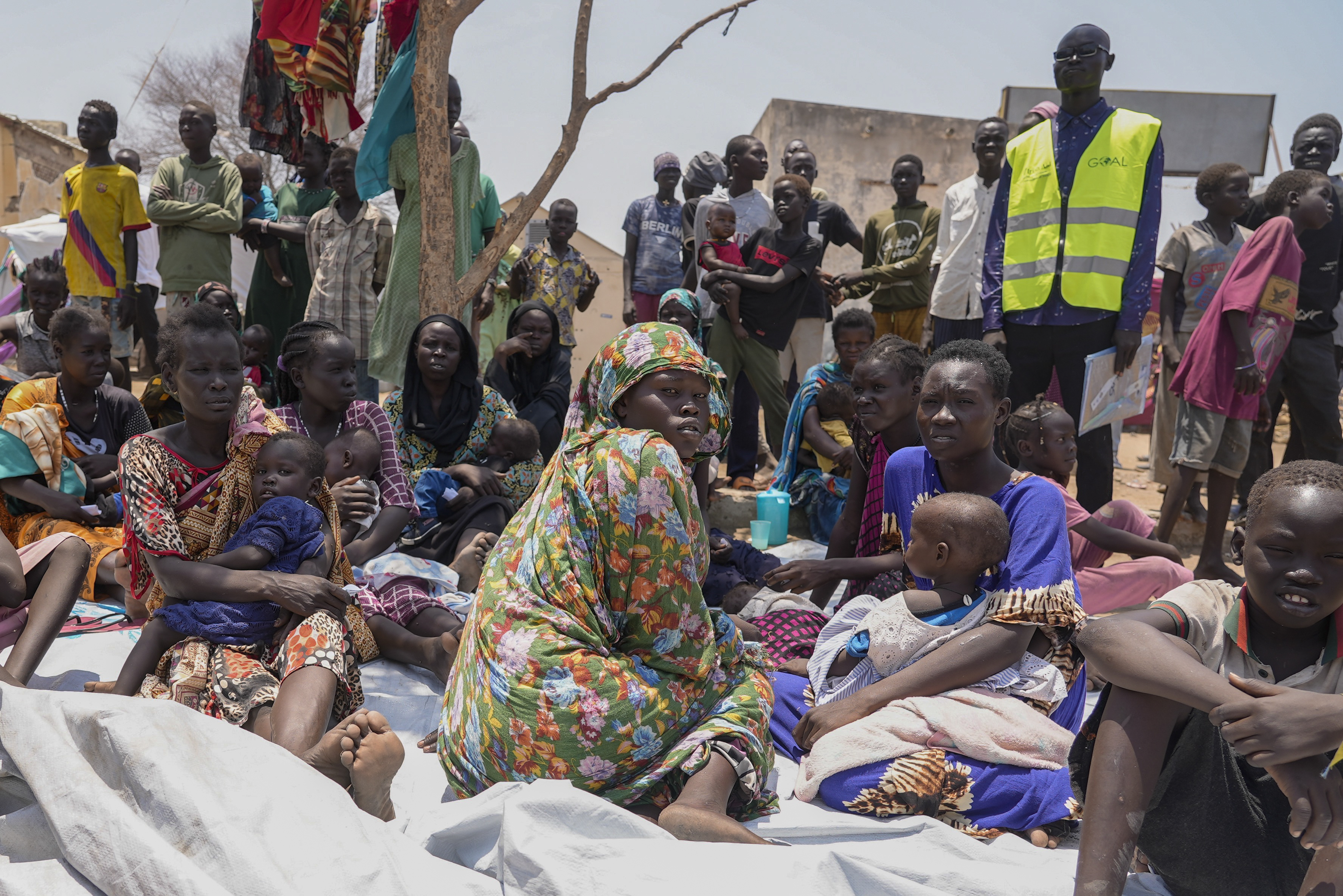 People who fled from Sudan sit outside a nutrition clinic in Renk, South Sudan