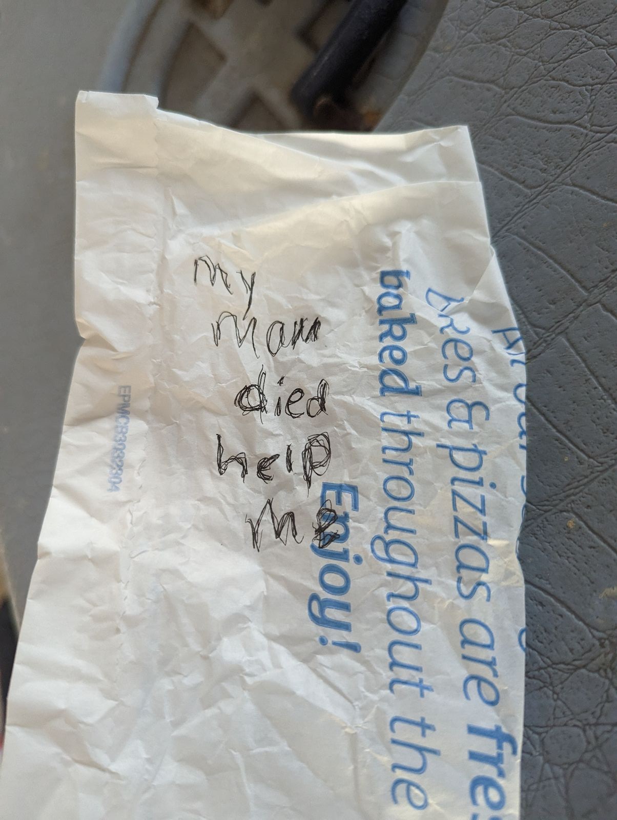 Note written with black pen on a white and blue paper bag