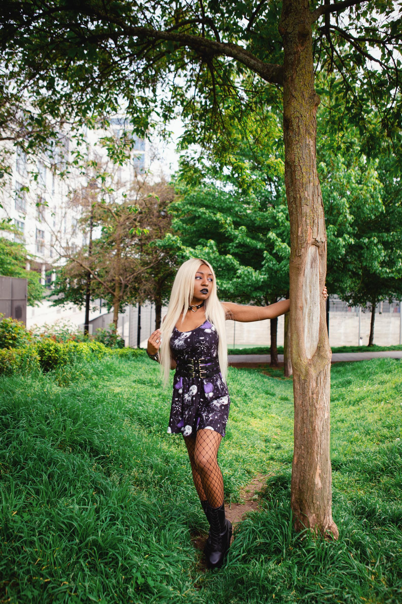 Woman looking to the side and resting her hand on a tree