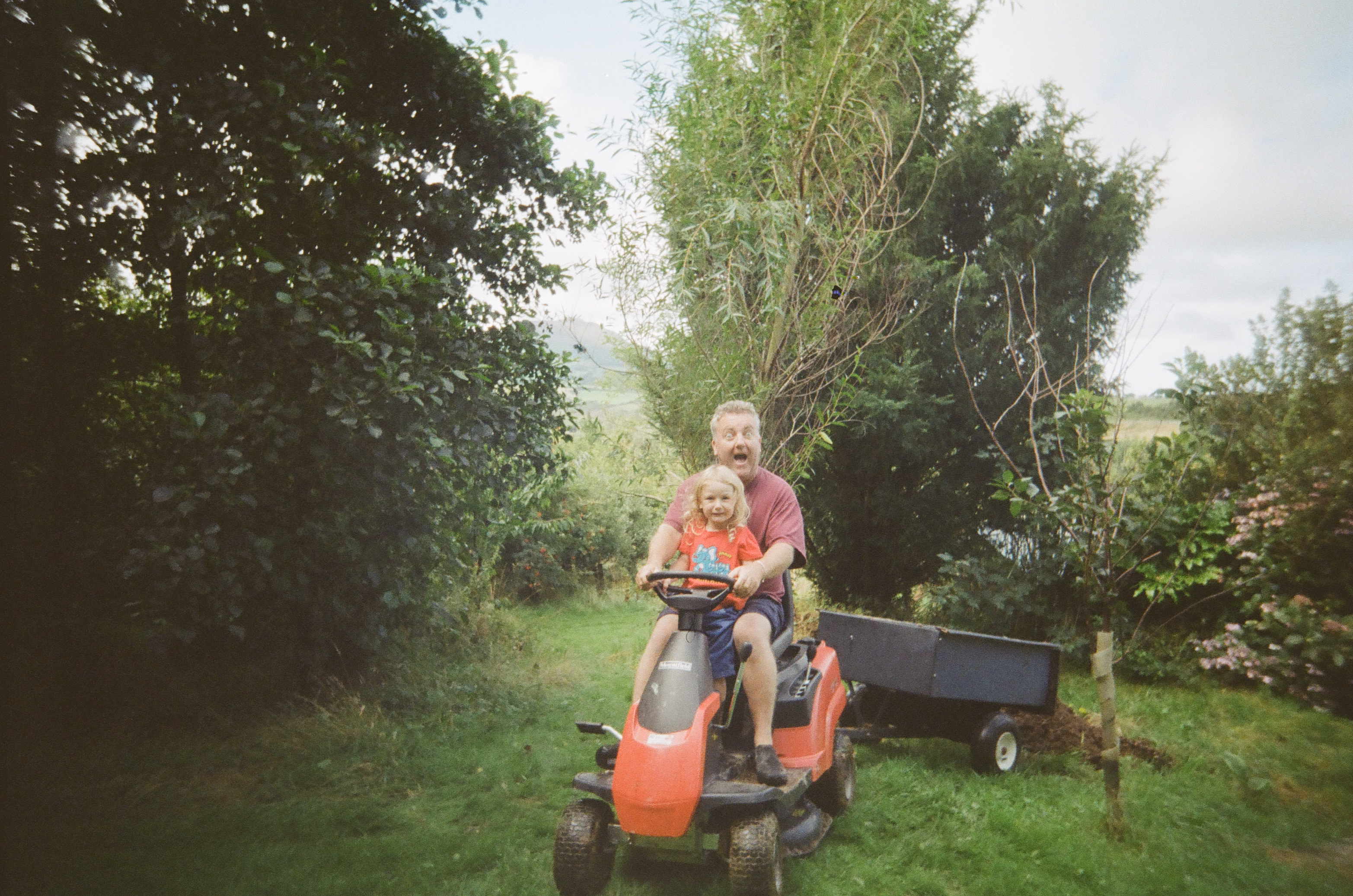 Jonathan Baxter and Lewis (front) riding a lawn mower