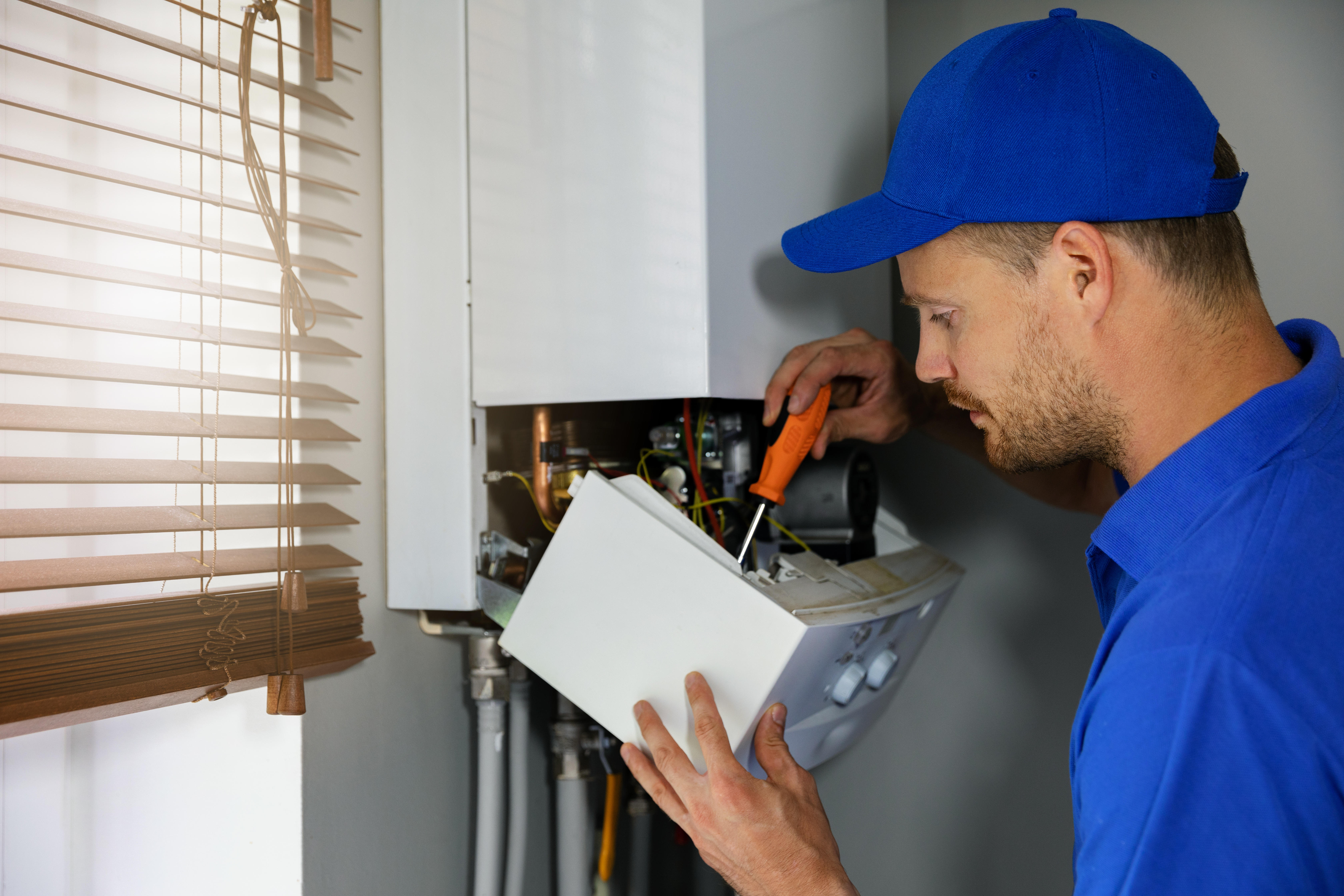 A gas maintenance man checking a boiler in someone's home