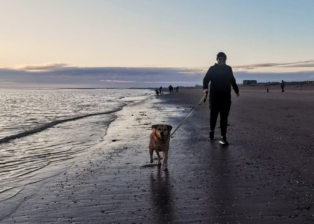 Simon and Bella enjoying a walk on the beach