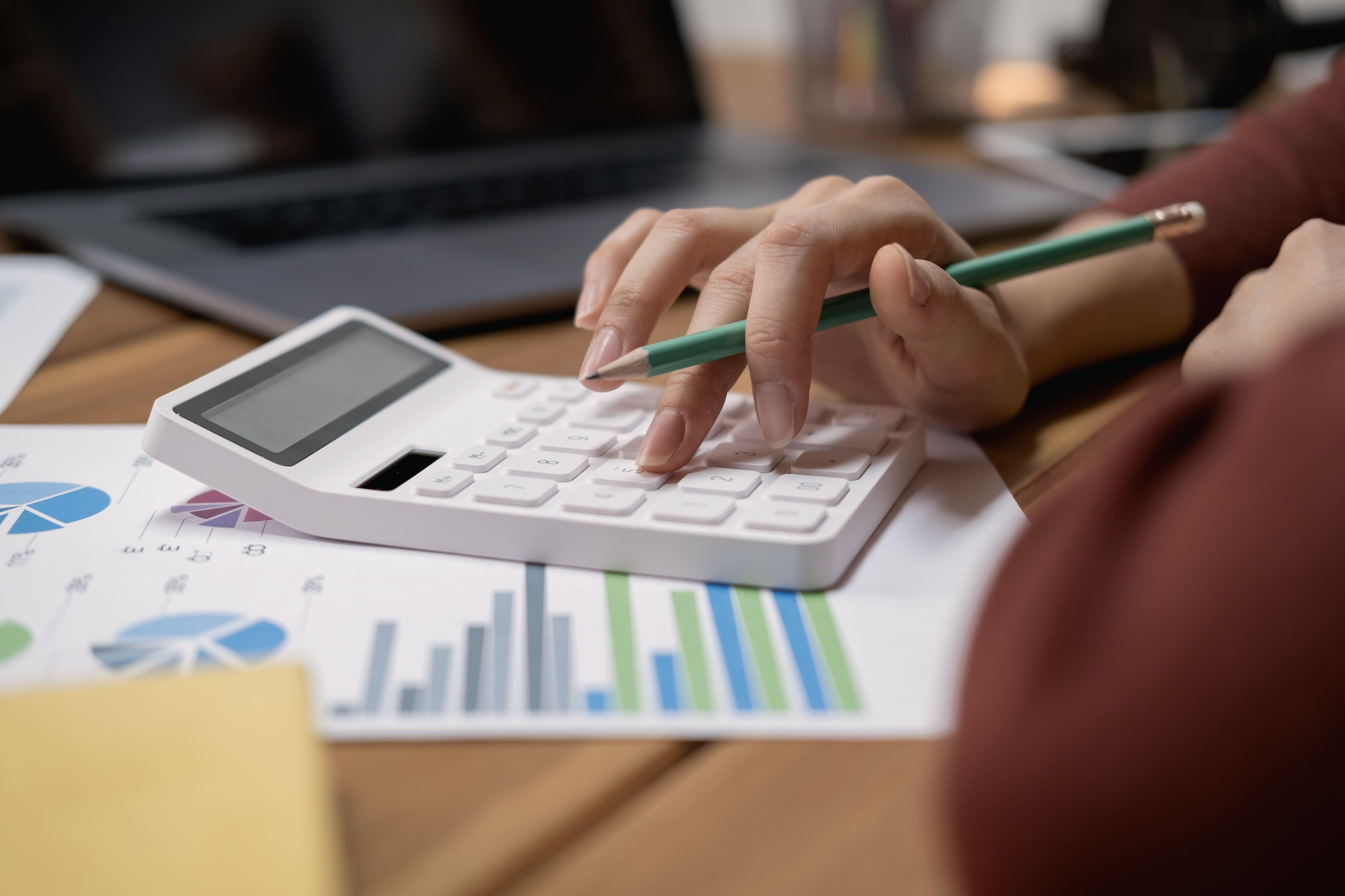 Close-up view of bookkeeper or financial inspector making report, calculating or checking balance