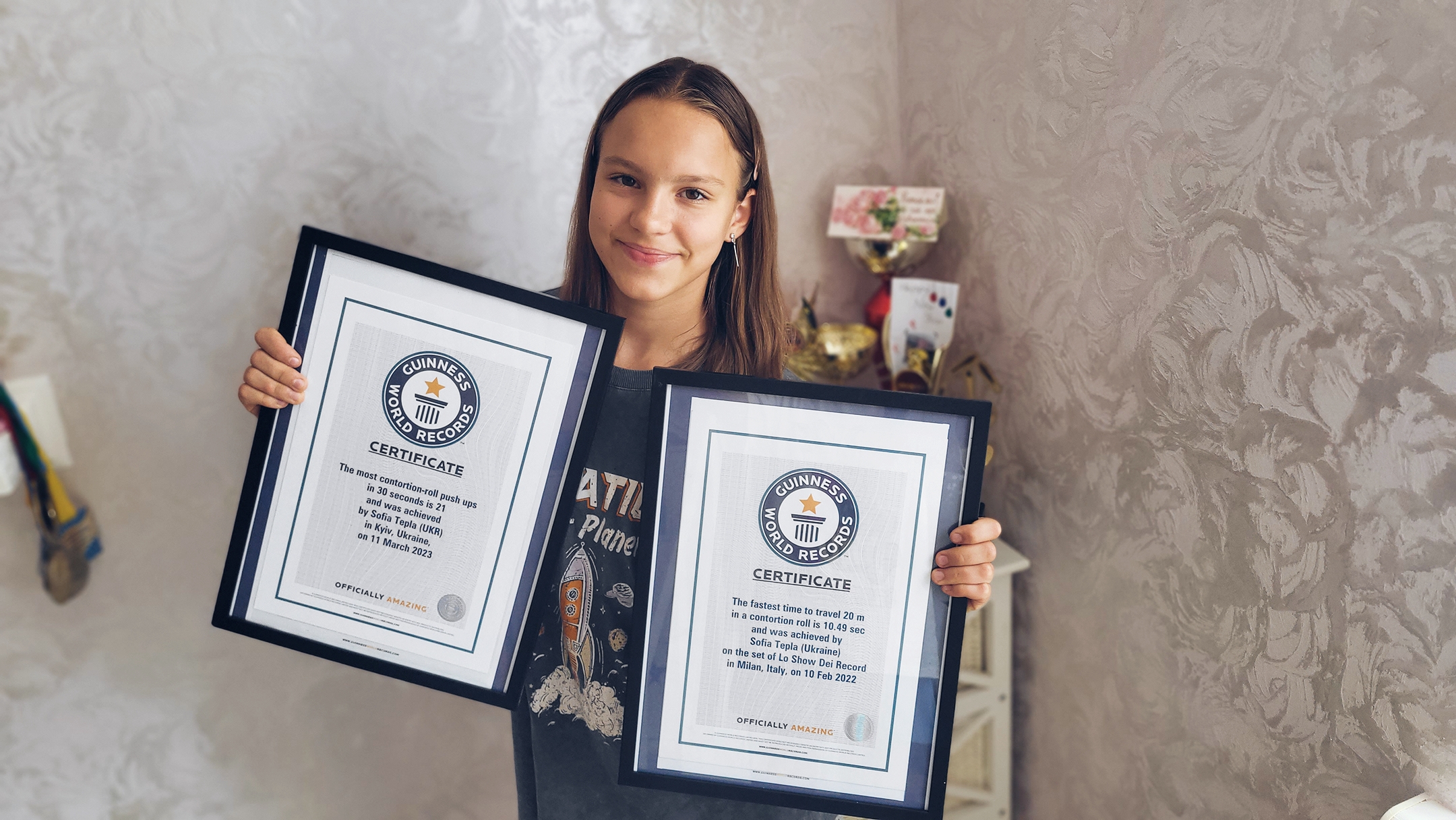 Girl holding two certificates 