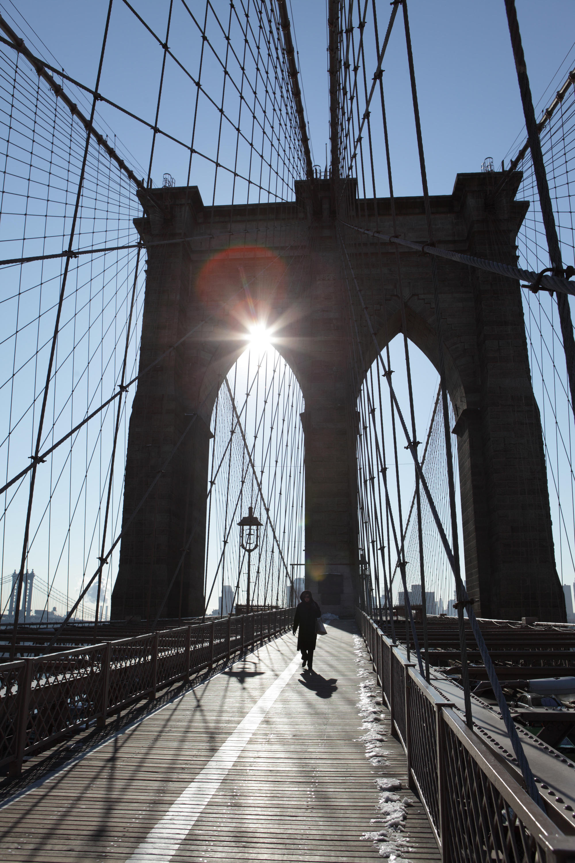 Woman walking across the Brooklyn Bridge