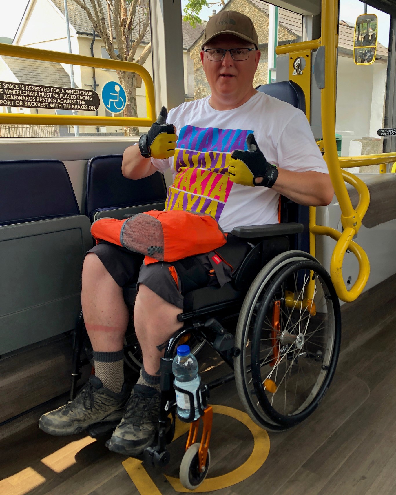 Man sitting in a wheelchair, with his thumbs up