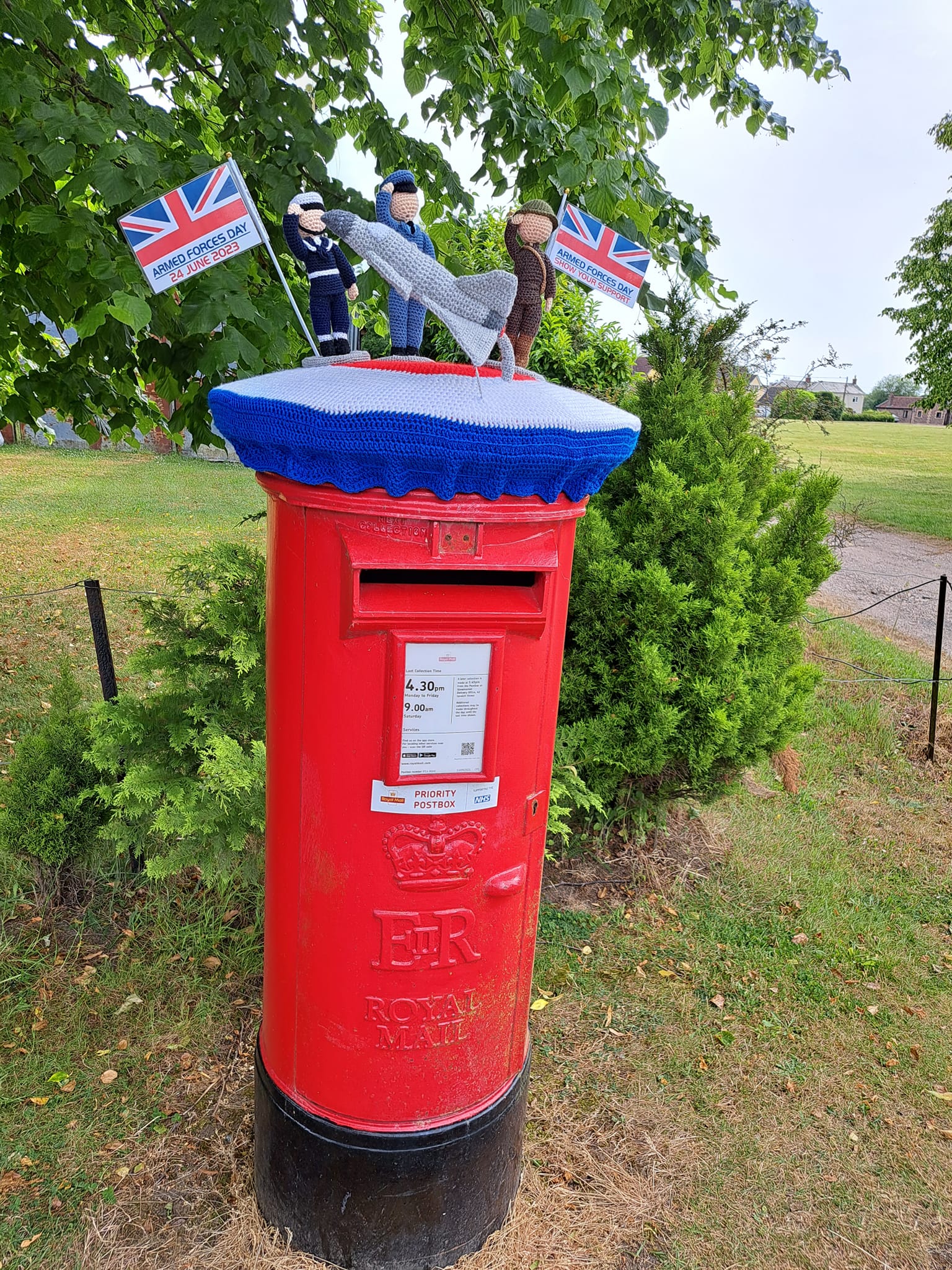 Crocheted figures on top of a postbox