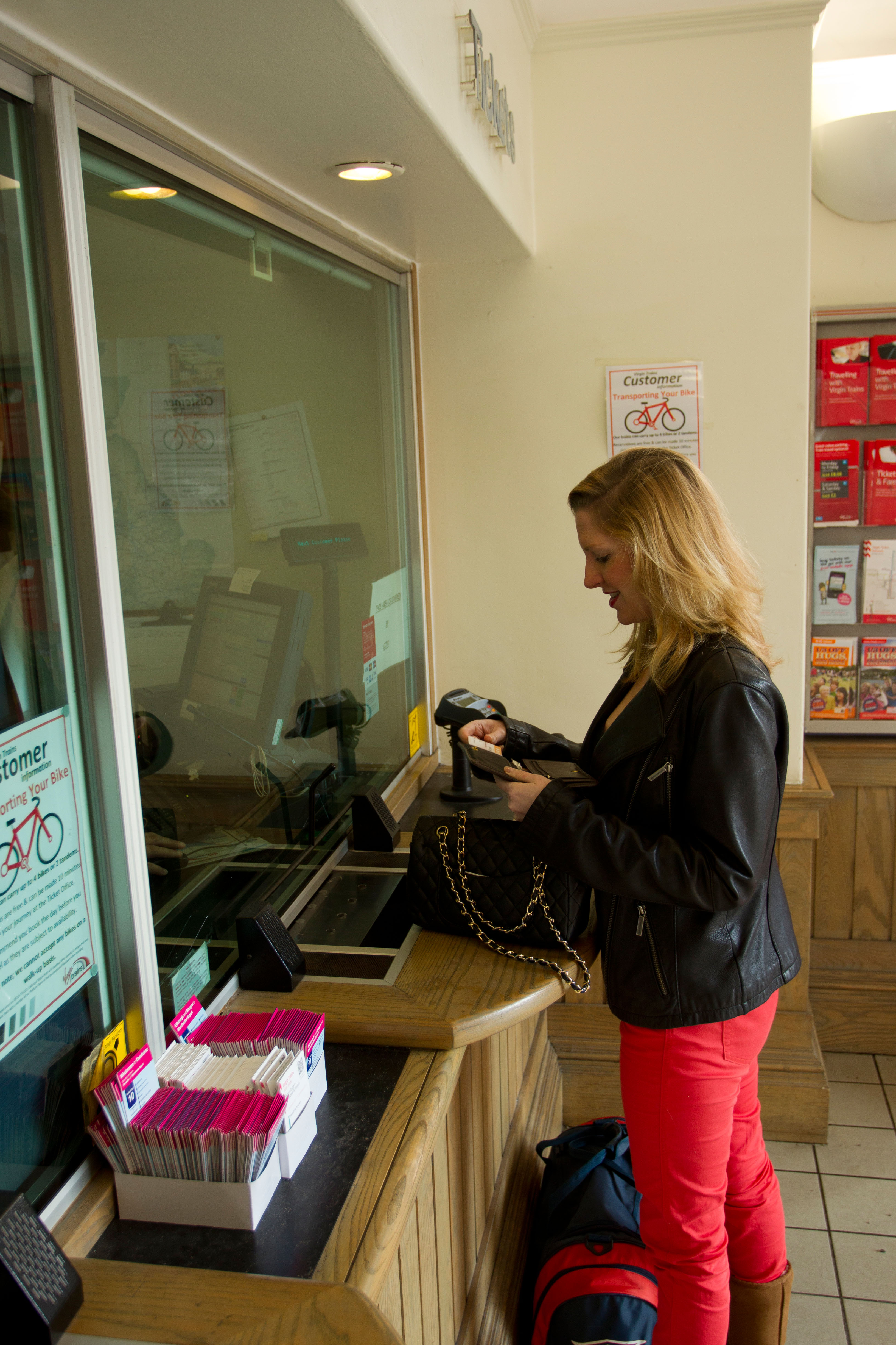 A woman buying a ticket from an office