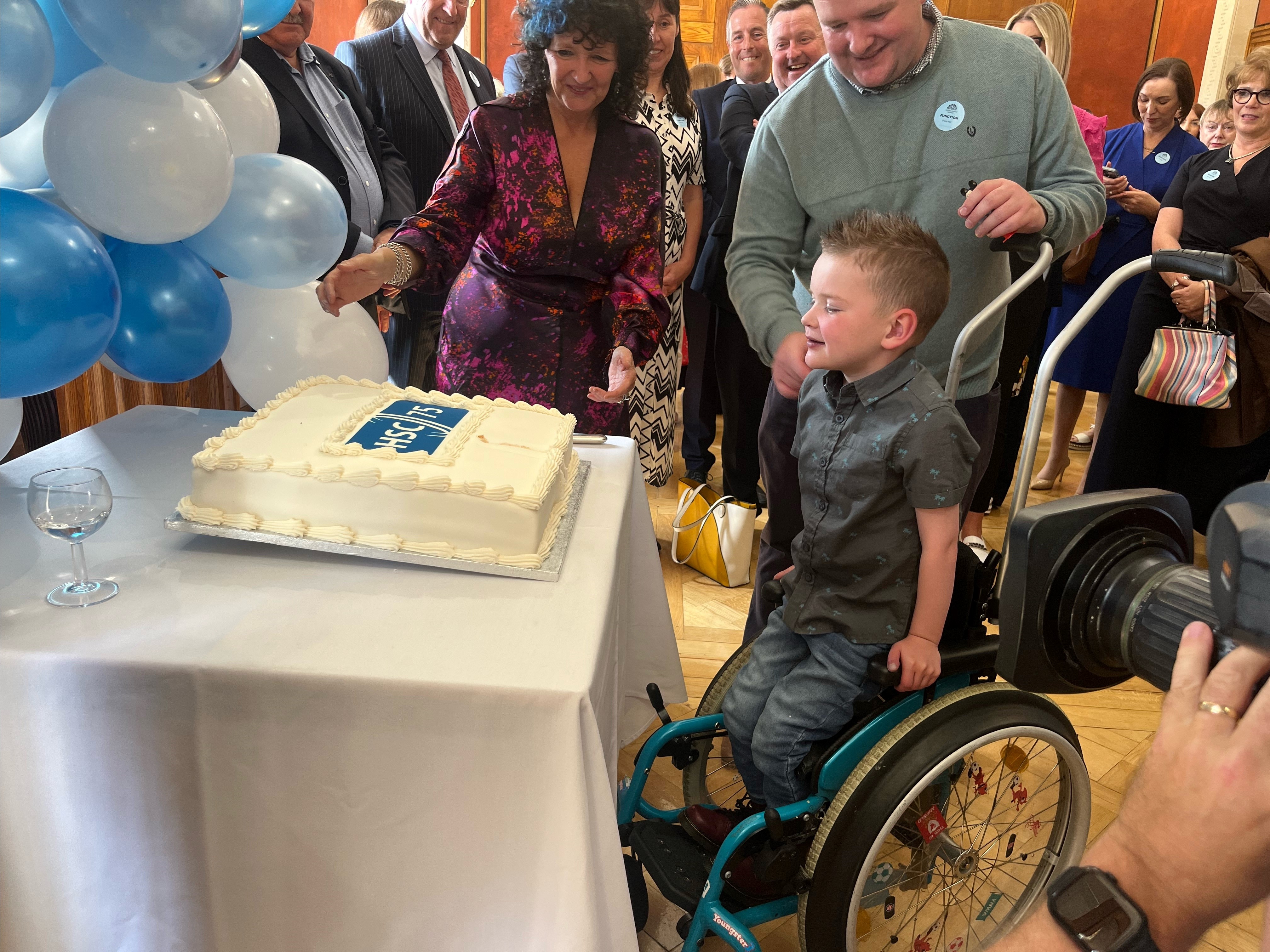 Daithi Mac Gabhann cuts a cake at Stormont to celebrate the 75th anniversary of the health service