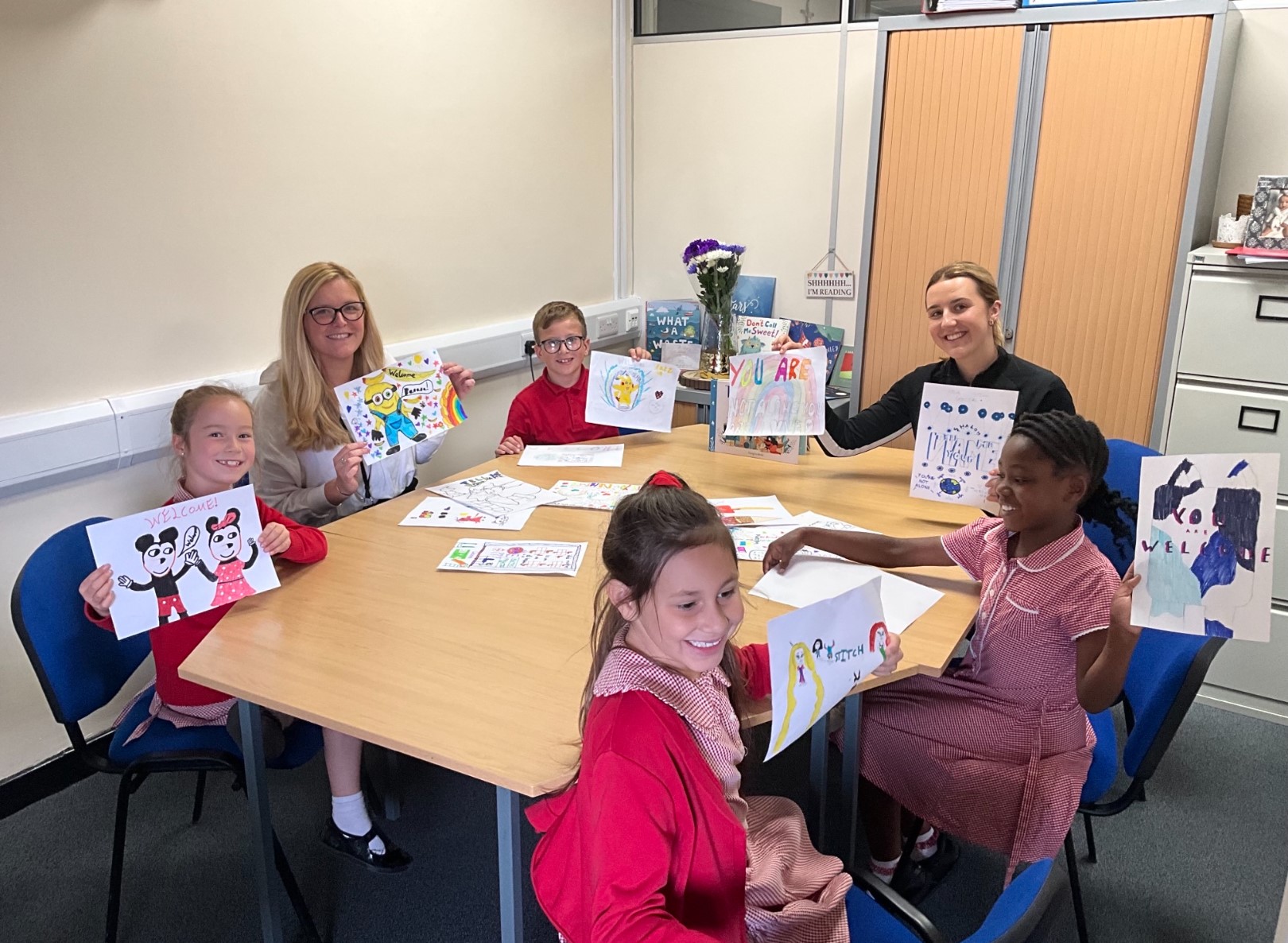 Pupils and teachers with their pictures 