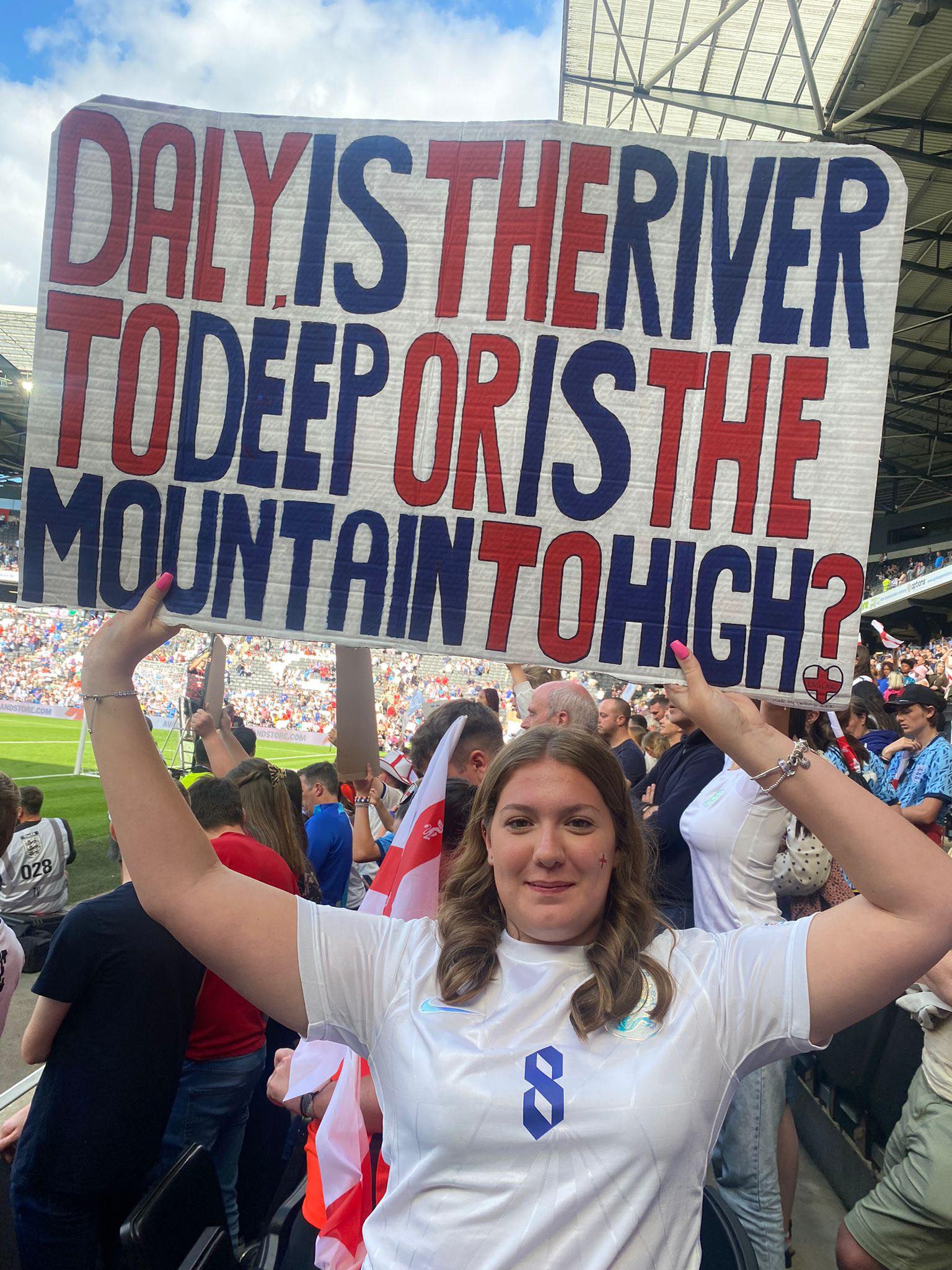 Caitlin Greshon at a football match holding up a sign 