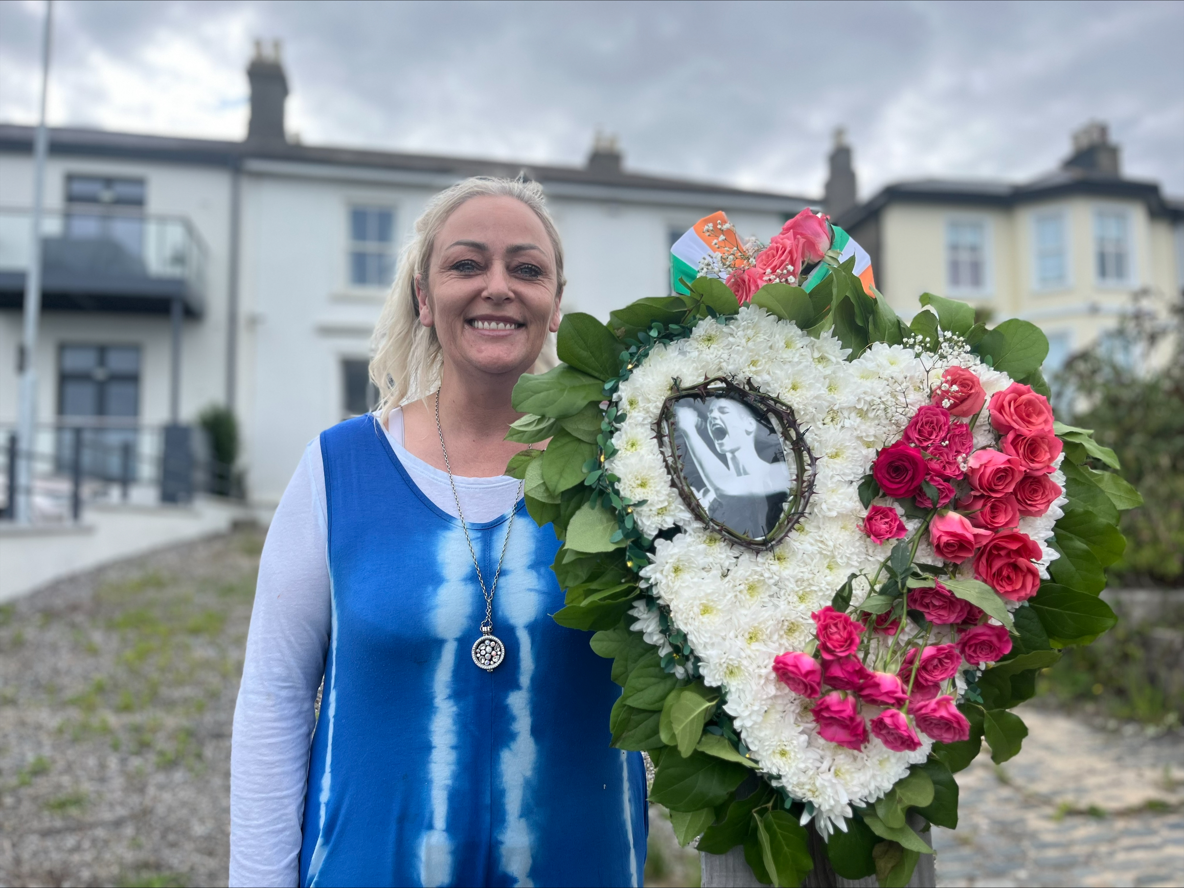 Karen Kehoe with a wreath she designed for Sinead O'Connor on behalf of victims of abuse in Ireland, laid outside the singer's former home in Bray Co. Wicklow. (Claudia Savage/PA).