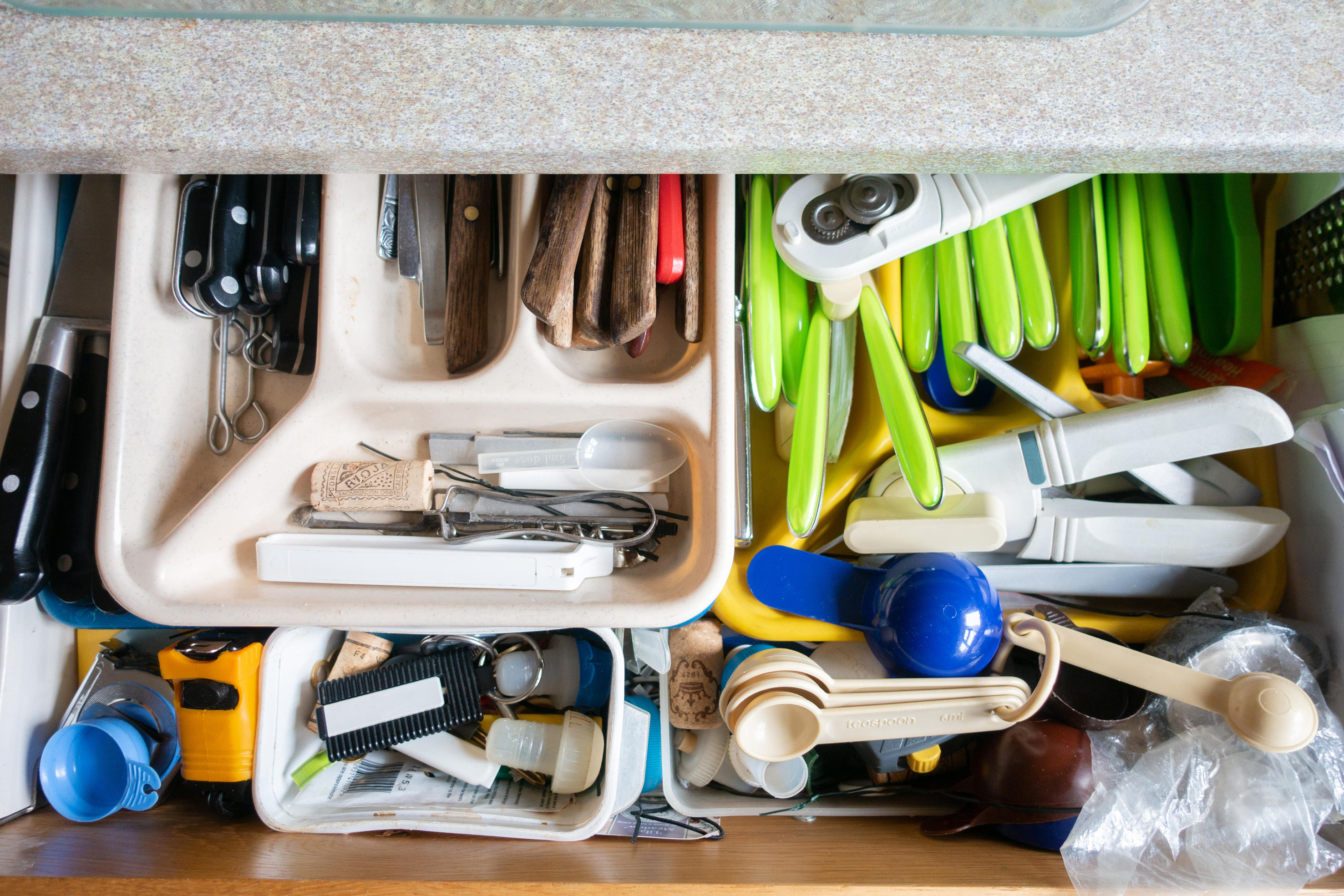 Contents of a cluttered kitchen drawer