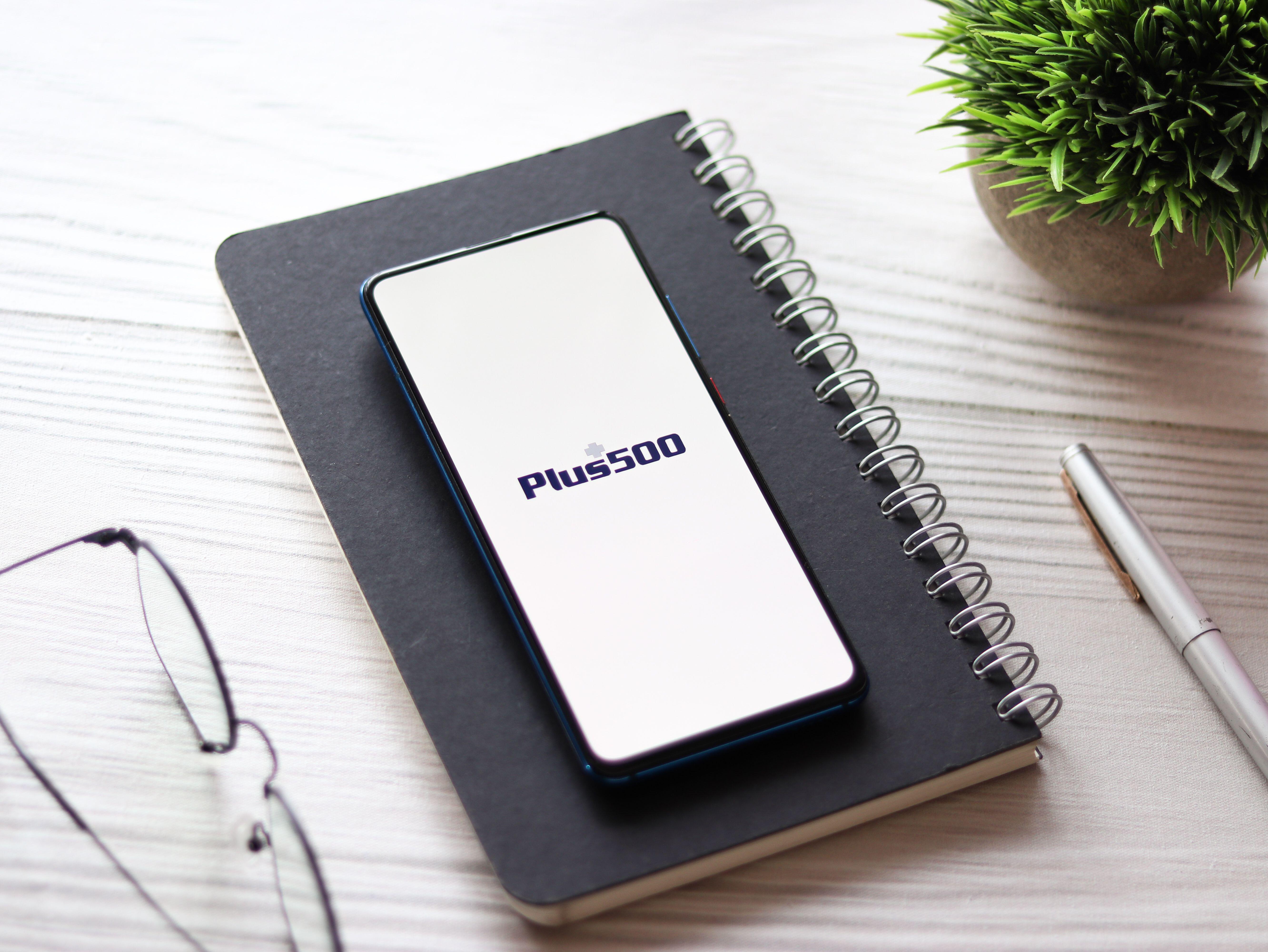 Plus500 logo on phone