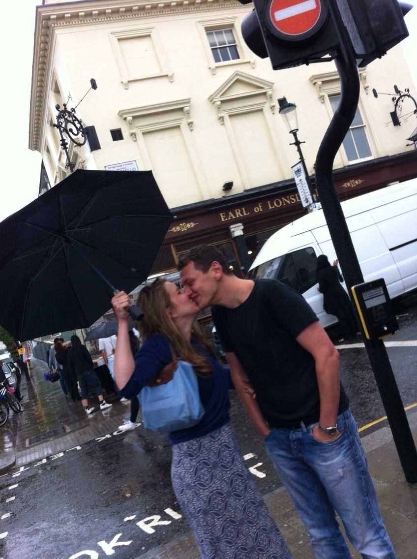 People kissing under an umbrella 