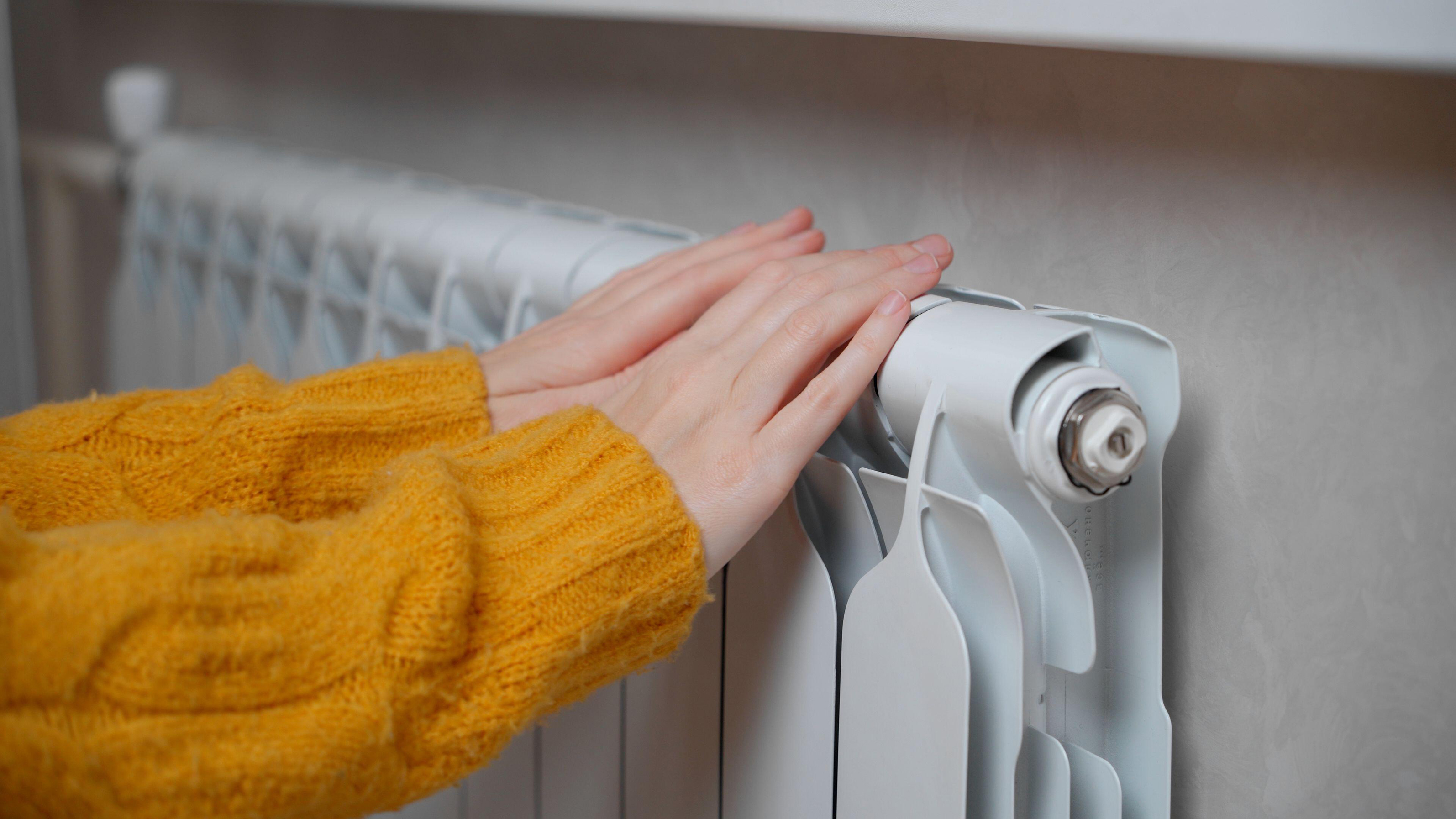 Woman touching radiator to see if it's warm