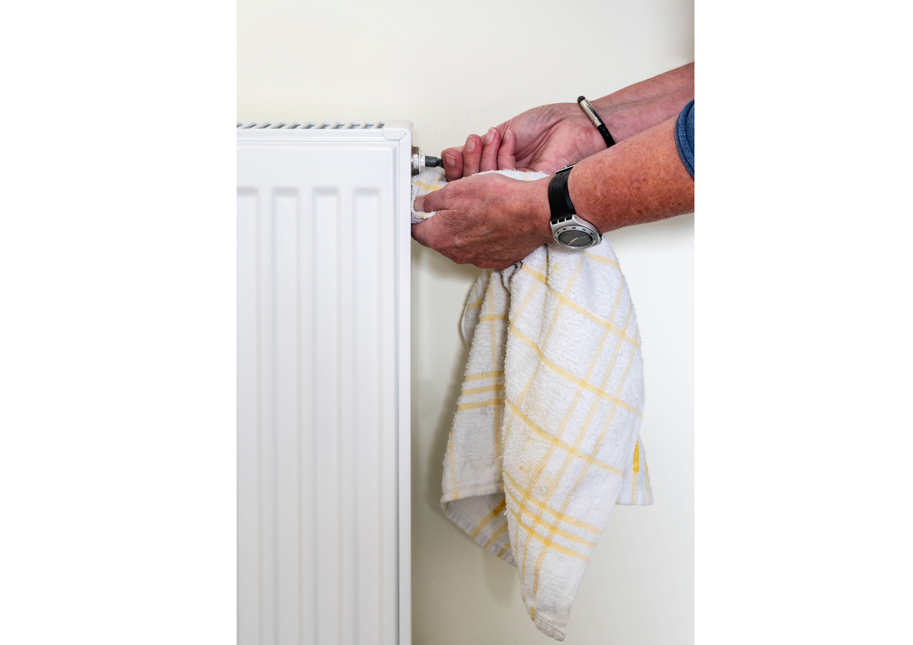 Man bleeding a radiator valve to release trapped air