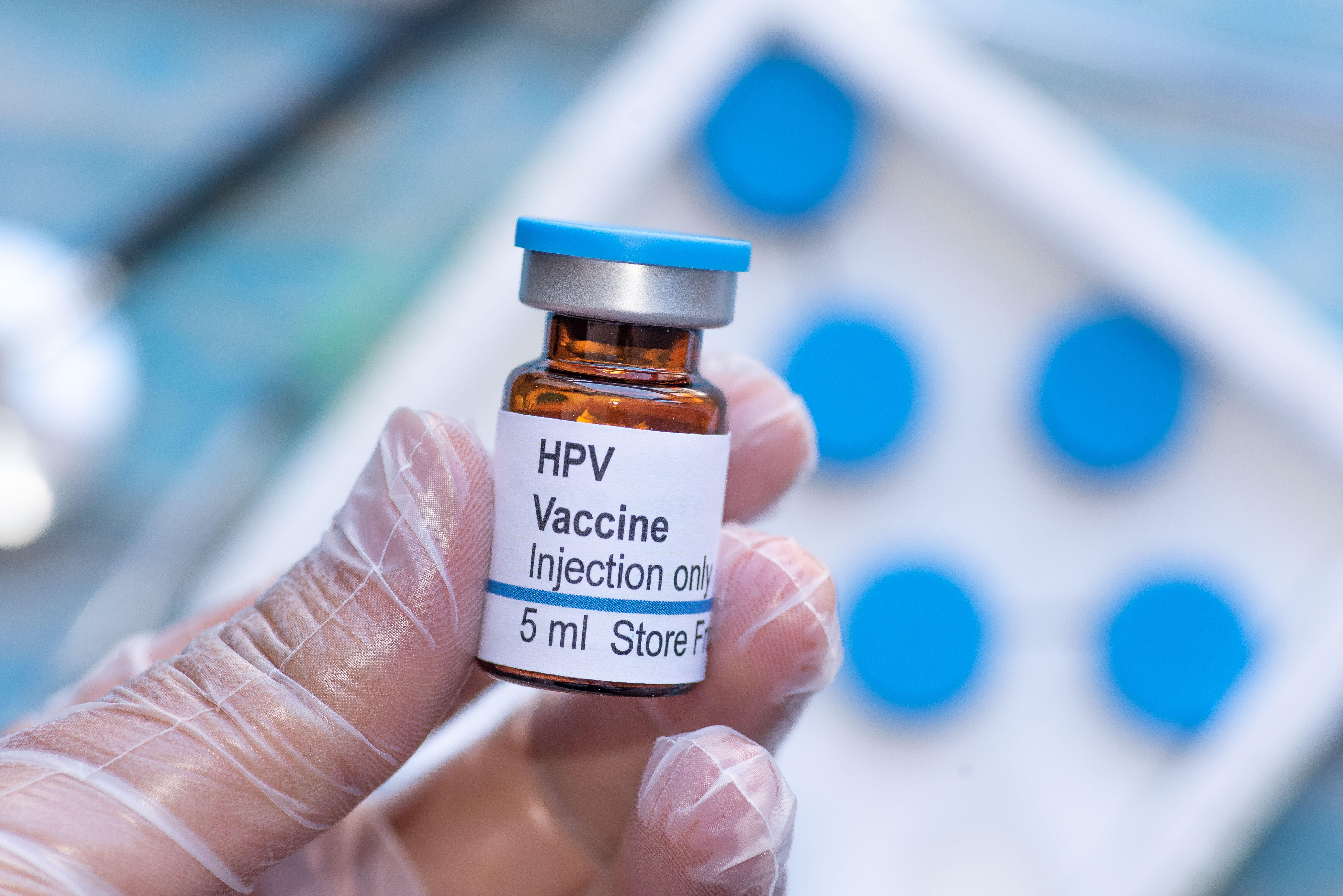 Hand holding vial of Human Papillomavirus (HPV) vaccine