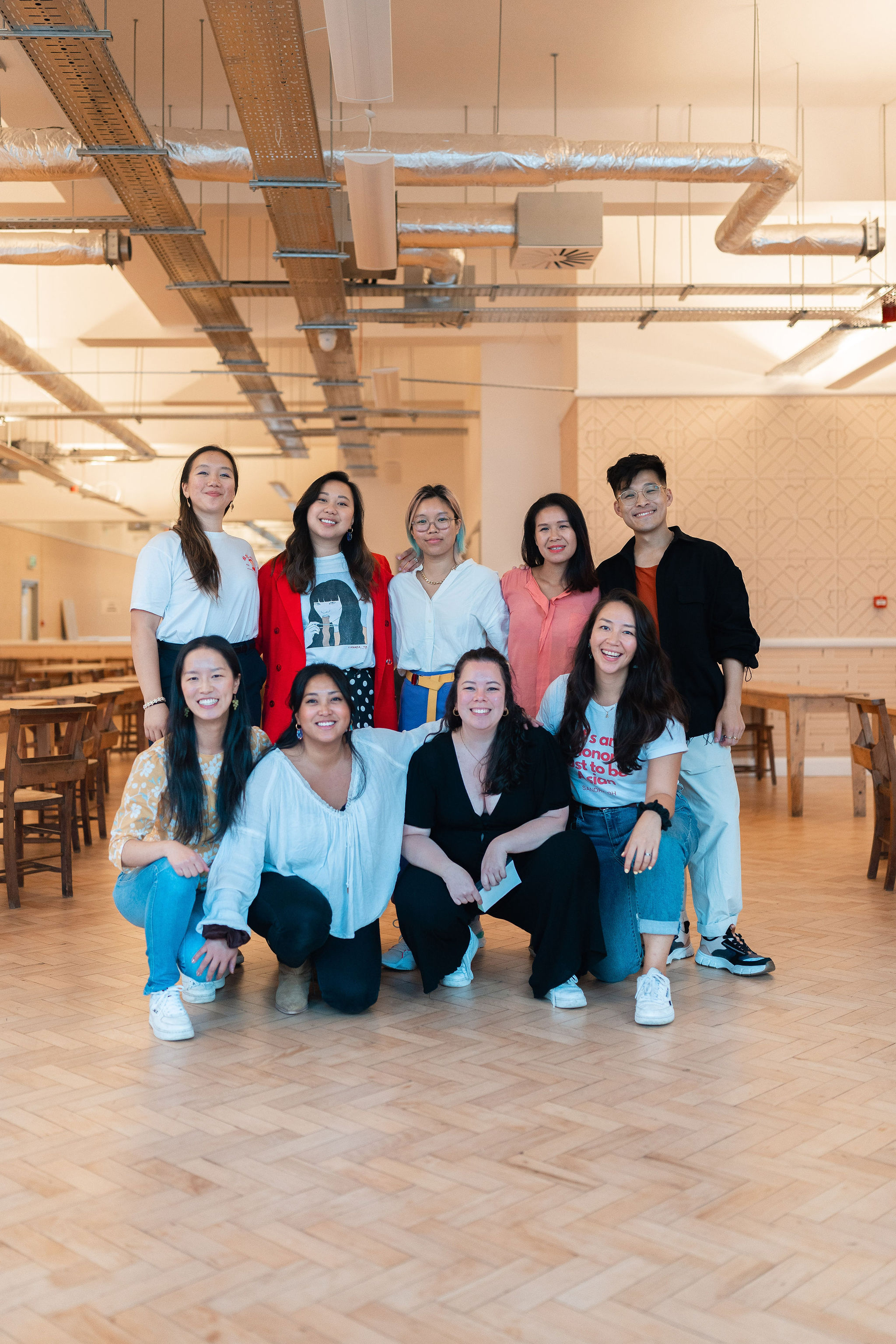 A group of nine people standing and crouching for a photo