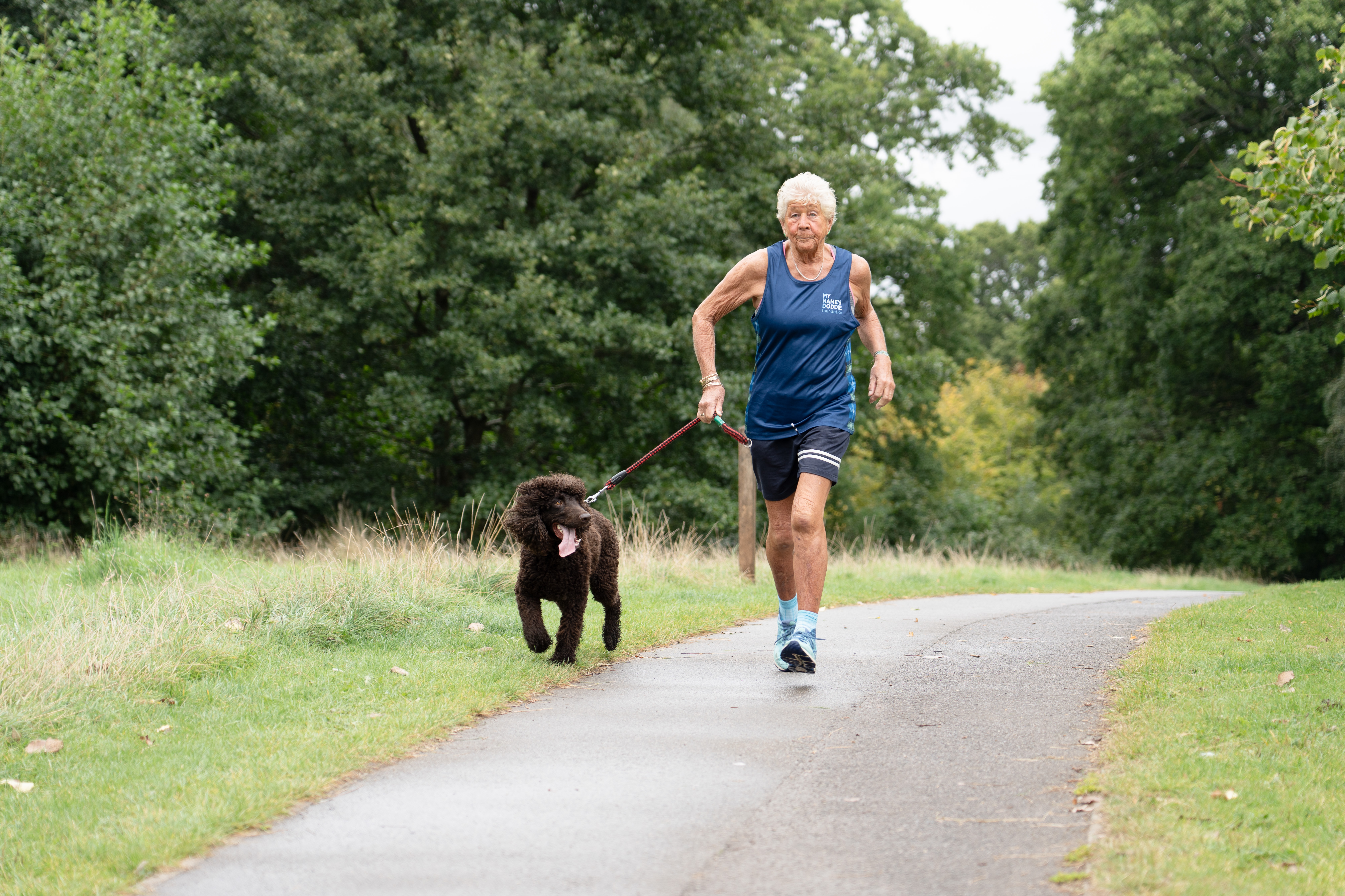 Caroline Quibell running through a park with her dog Streak