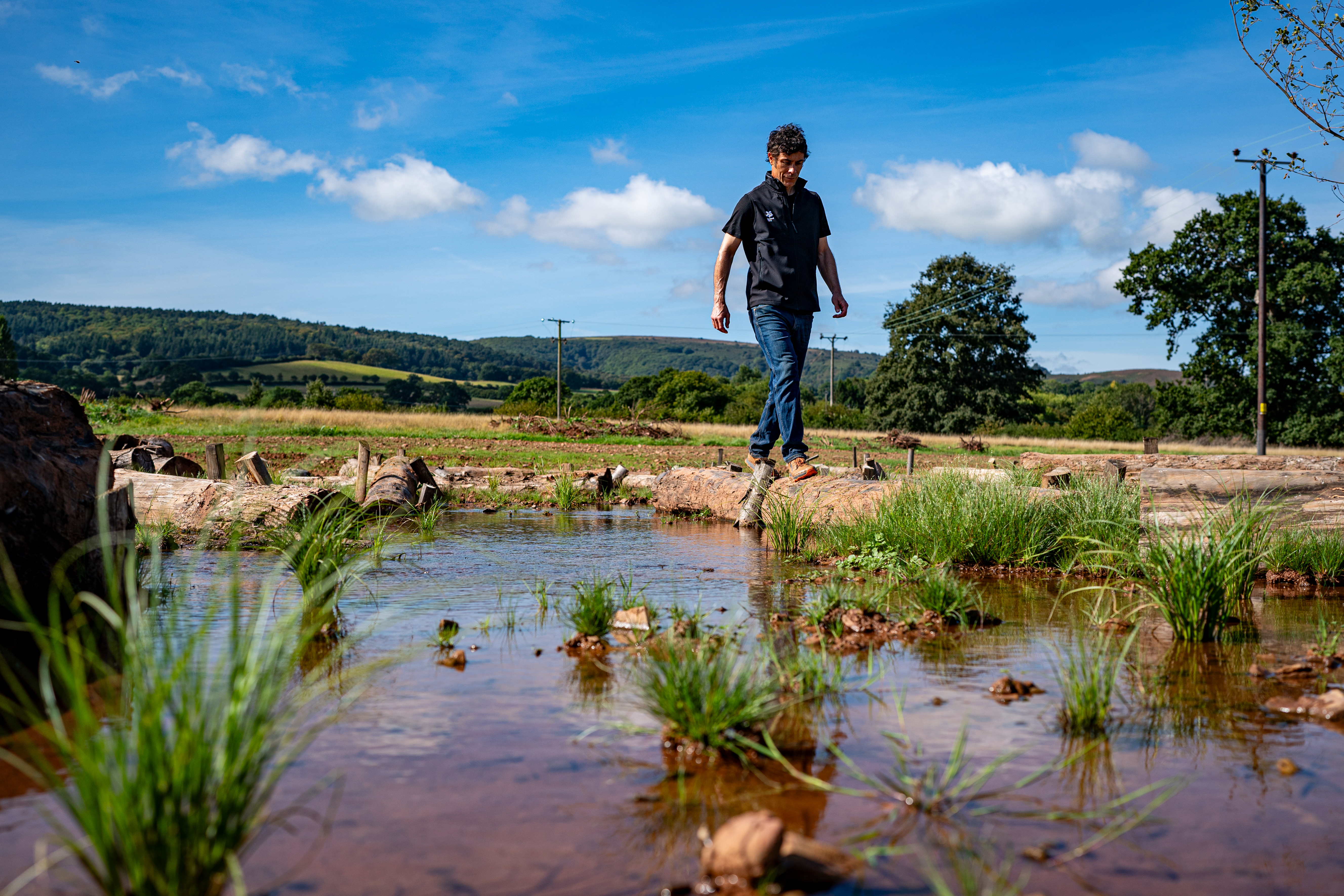 Ben Eardley, National Trust project manager, stands on one of hundreds of logs placed on the newly reconnected floodplain 