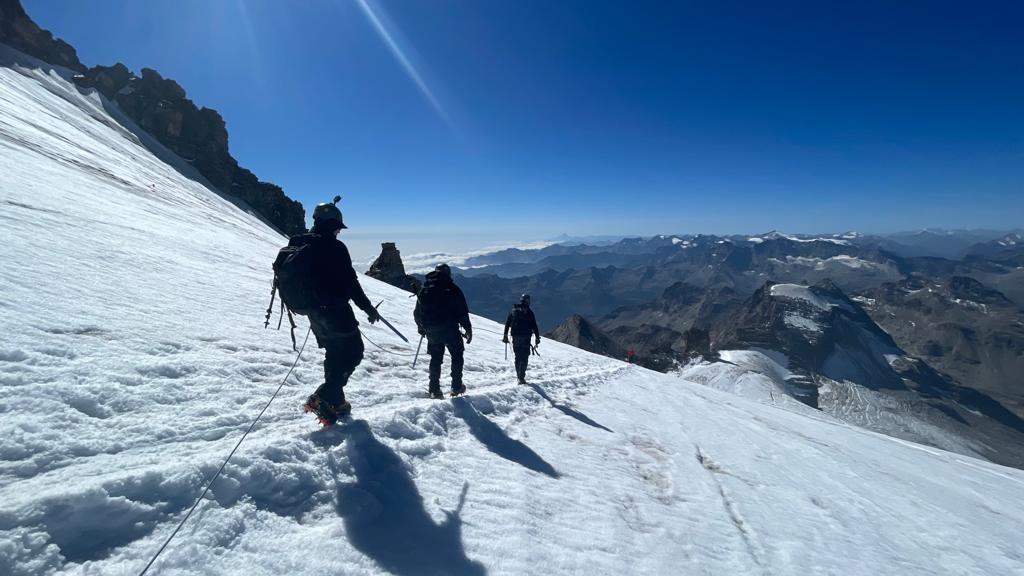 The three former players walking through snow during their challenge 