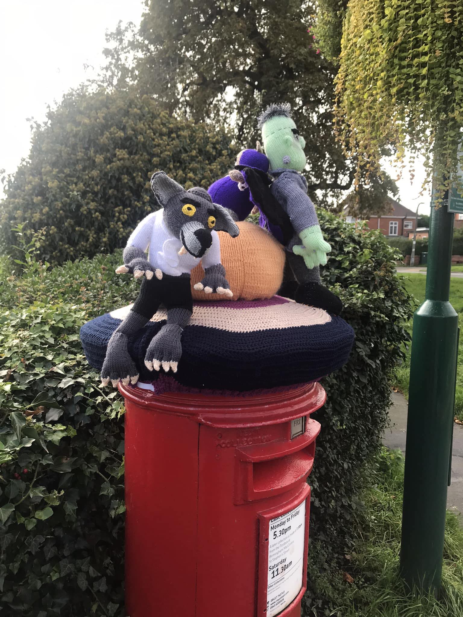 Knitted and crocheted items on top of a postbox